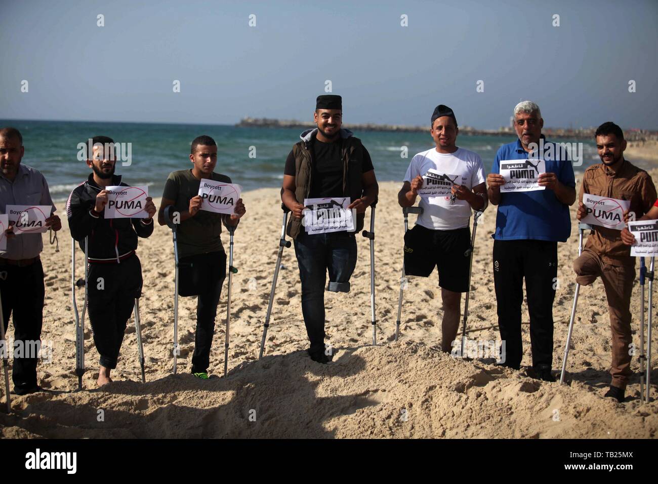 May 29, 2019 - Gaza City, Gaza Strip, Palestinian Territory - Wounded Palestinians, who were lose their legs during the clashes with Israeli troops, hold placards during a protest calling to boycott Puma sport company, on the beach of Gaza city on May 29, 2019. Puma is the main sponsor of the Israel Football Association (IFA), which includes teams in Israelâ€™s illegal settlements on occupied Palestinian  (Credit Image: © Mahmoud Ajjour/APA Images via ZUMA Wire) Stock Photo