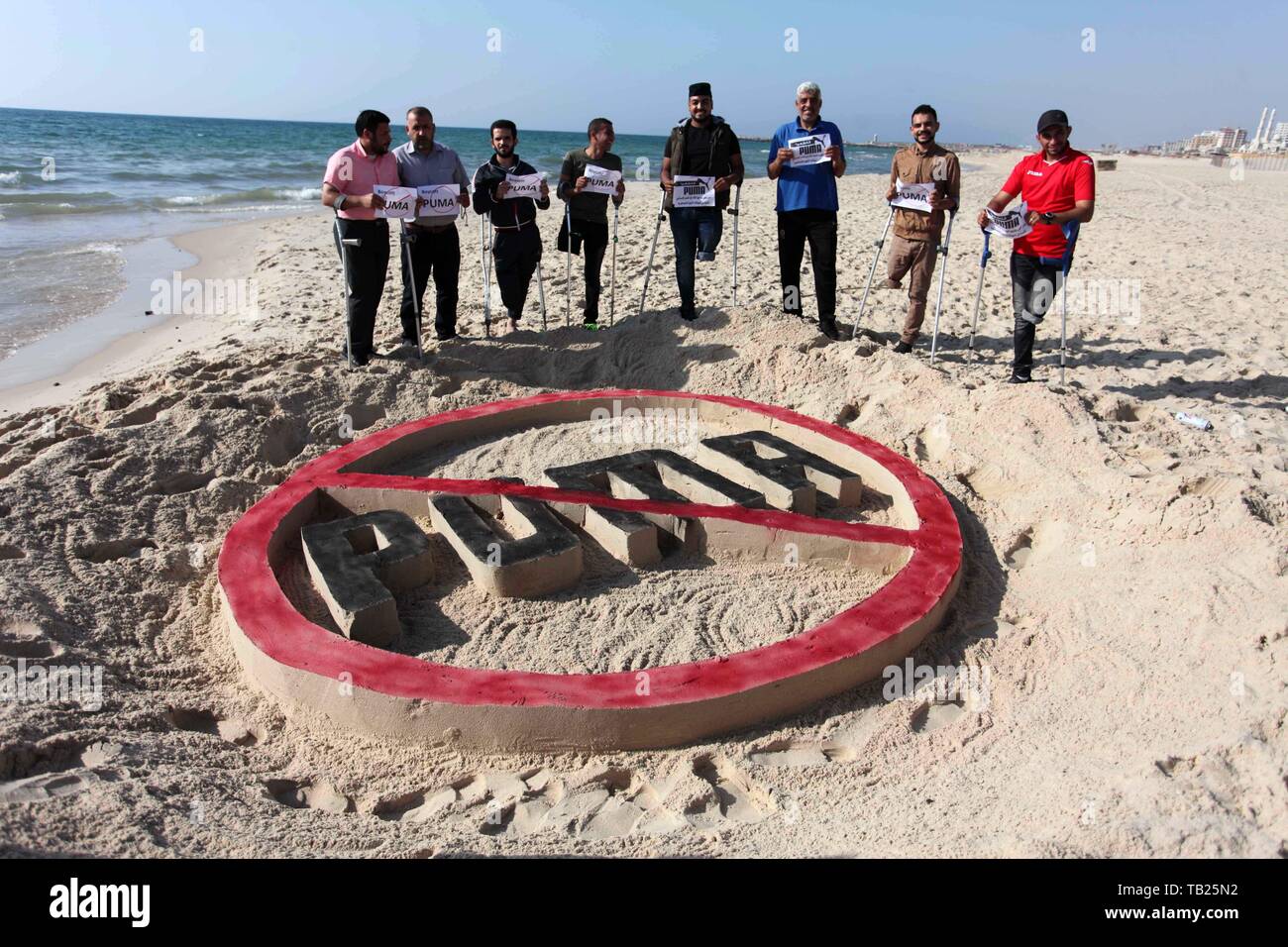 May 29, 2019 - Gaza City, Gaza Strip, Palestinian Territory - Wounded Palestinians, who were lose their legs during the clashes with Israeli troops, stand in front a sand draw during a protest calling to boycott Puma sport company, on the beach of Gaza city on May 29, 2019. Puma is the main sponsor of the Israel Football Association (IFA), which includes teams in Israelâ€™s illegal settlements on occupied Palestinian land  (Credit Image: © Mahmoud Ajjour/APA Images via ZUMA Wire) Stock Photo