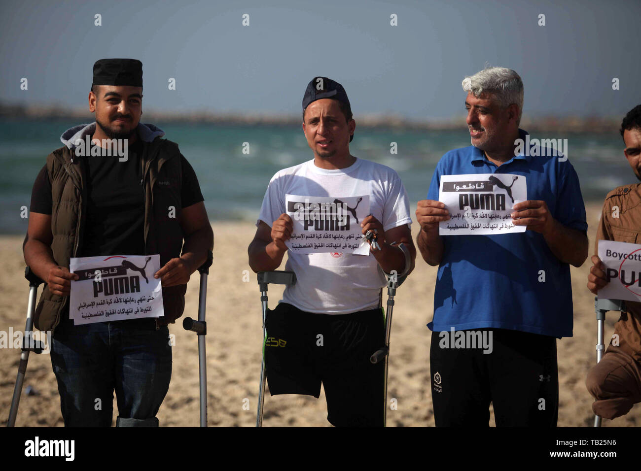 May 29, 2019 - Gaza City, Gaza Strip, Palestinian Territory - Wounded Palestinians, who were lose their legs during the clashes with Israeli troops, hold placards during a protest calling to boycott Puma sport company, on the beach of Gaza city on May 29, 2019. Puma is the main sponsor of the Israel Football Association (IFA), which includes teams in Israelâ€™s illegal settlements on occupied Palestinian  (Credit Image: © Mahmoud Ajjour/APA Images via ZUMA Wire) Stock Photo