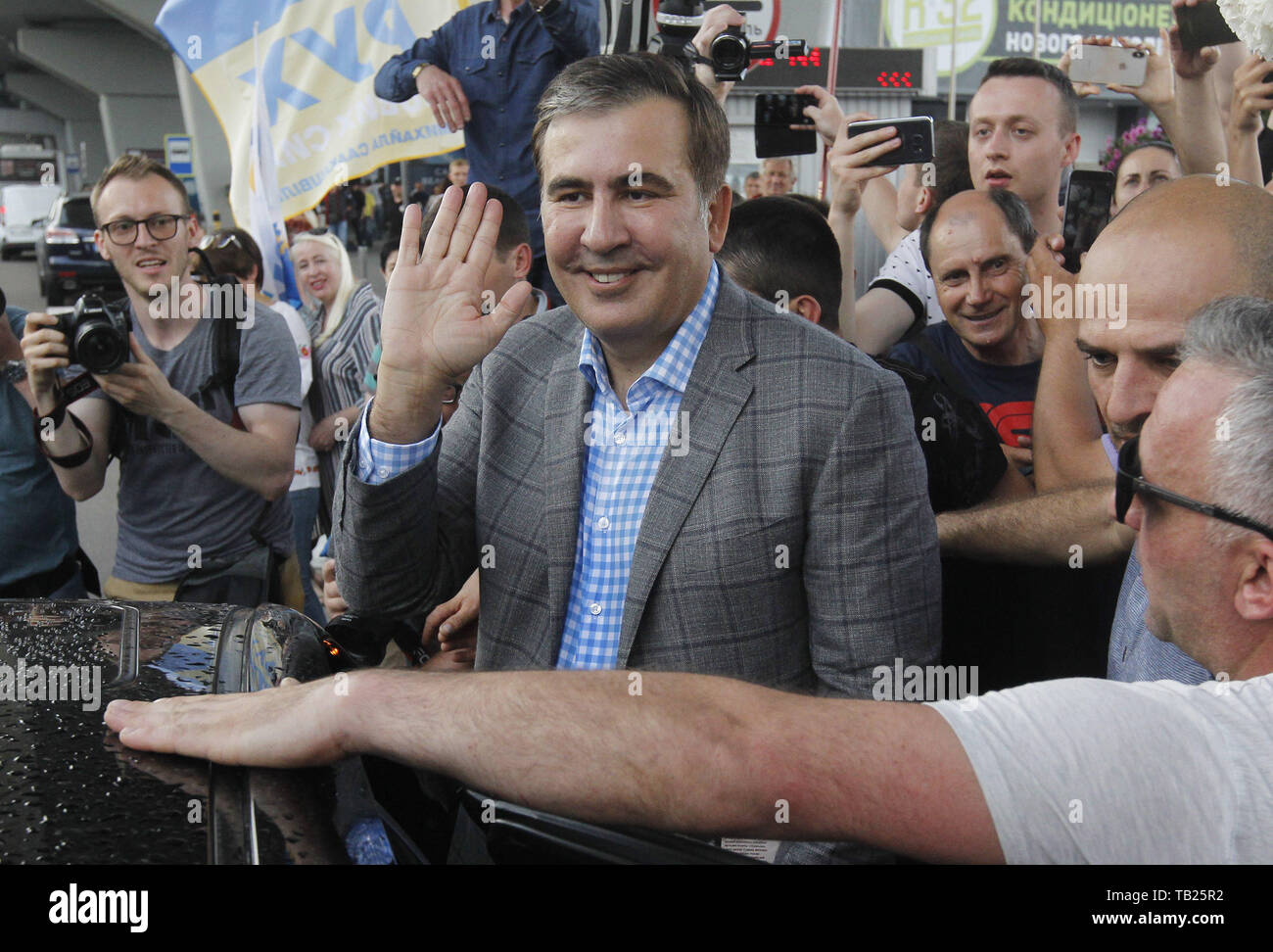 Kiev, Ukraine. 29th May, 2019. Former Georgian president and ex-Odessa Governor MIKHEIL SAAKASHVILI greets his supporters, as he arrives to the Boryspil international airport near Kiev, Ukraine, on 29 May 2019. Saakashvili returned to Ukraine after Ukrainian President Volodymyr Zelensky has reinstated Mikheil Saakashvili's Ukrainian citizenship on 28 May 2019. Zelensky deleted the respective provision from his predecessor Petro Poroshenko's No. 196 order dated July 26, 2017, the UNIAN inform agency reported. Ukrainian opposition leader Mikheil Saakashvili was deported to Poland on 12 February Stock Photo