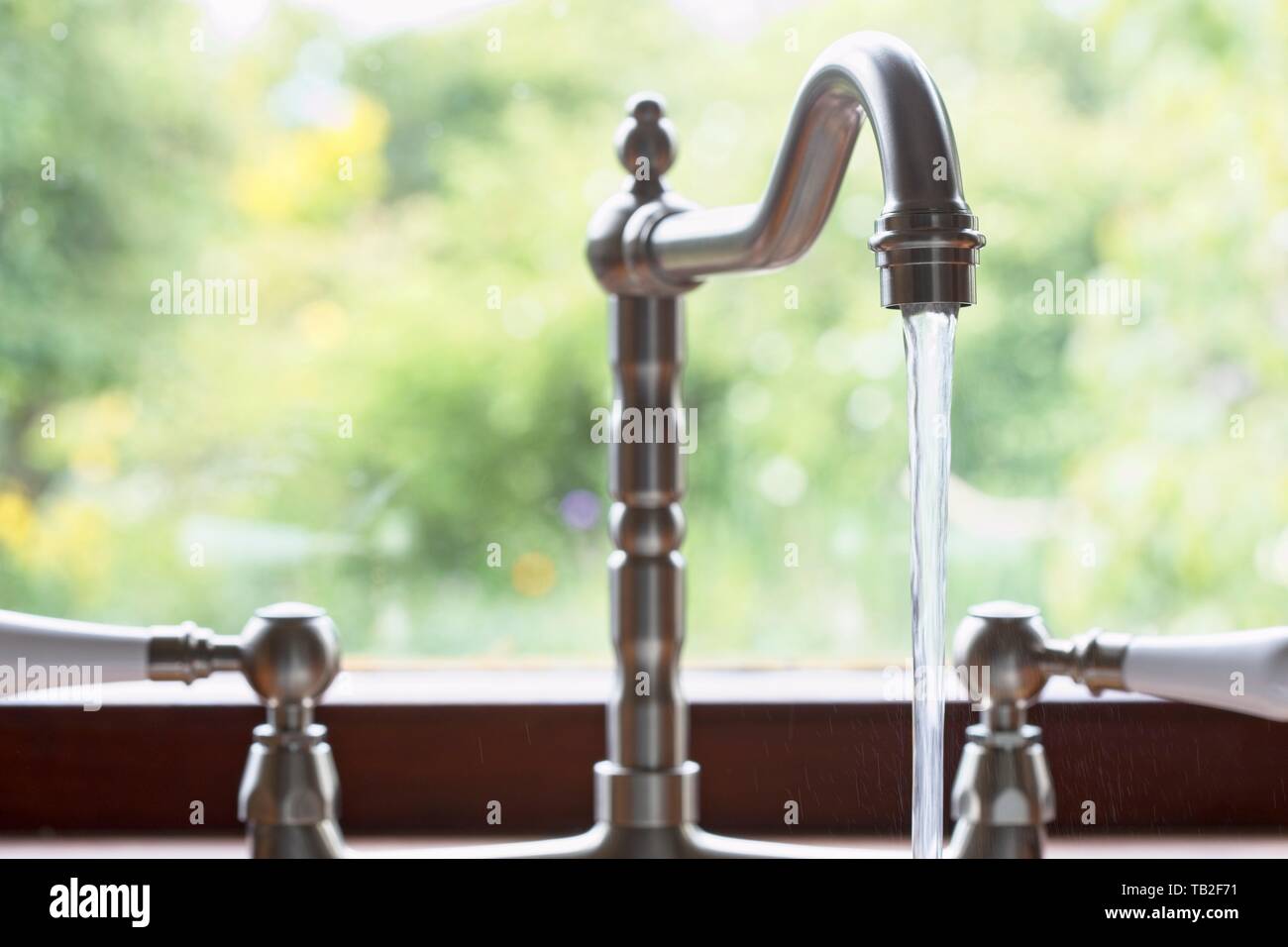Kitchen taps left running and wasting water. Uk. Stock Photo