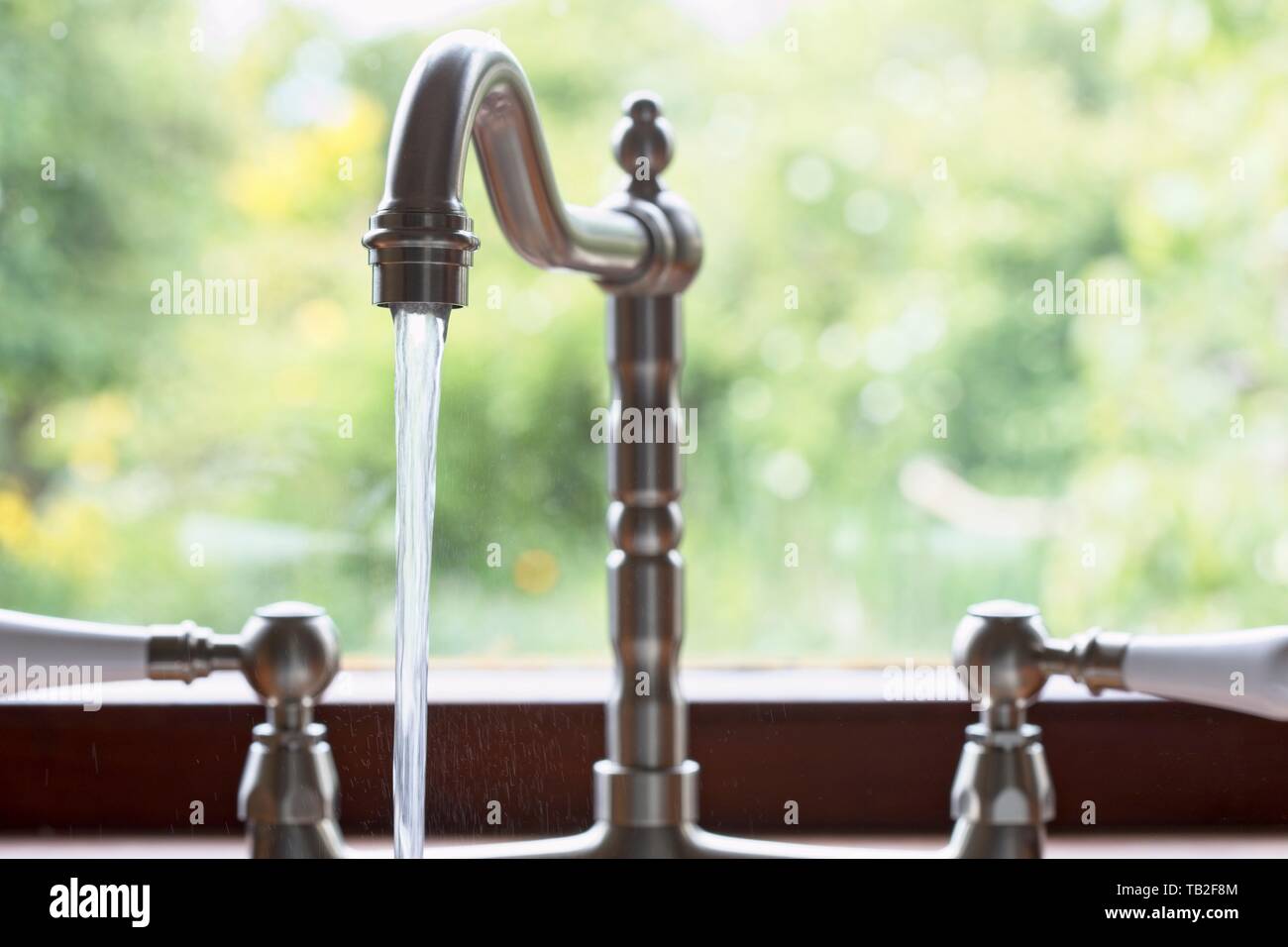 Kitchen taps left running and wasting water. Uk Stock Photo Alamy