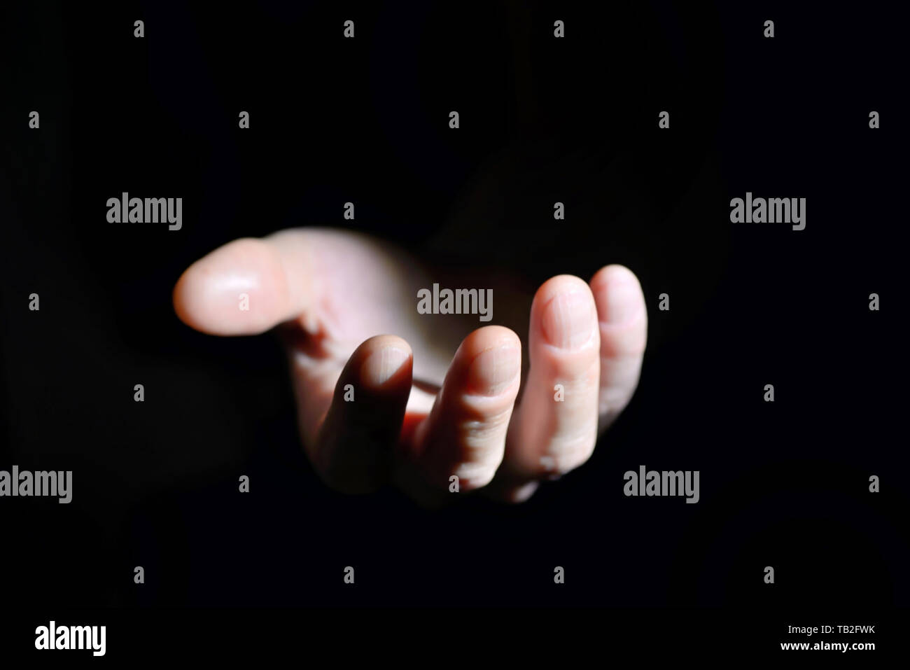Symbolic hand helping on black background Stock Photo