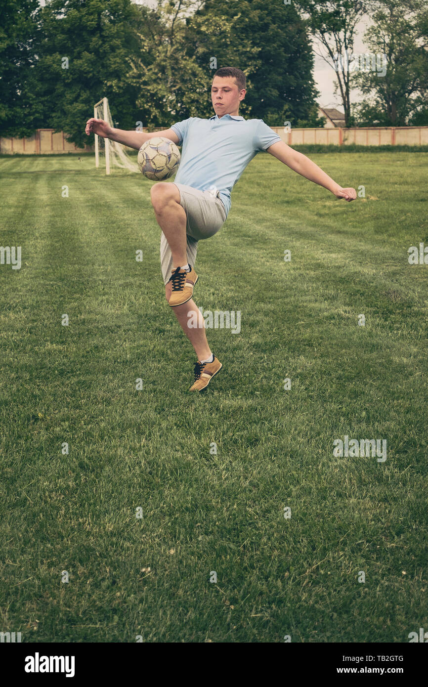 Young player practicing ball control with a soccer ball bouncing it on his upper leg during training fro a game or competition on a sports field Stock Photo