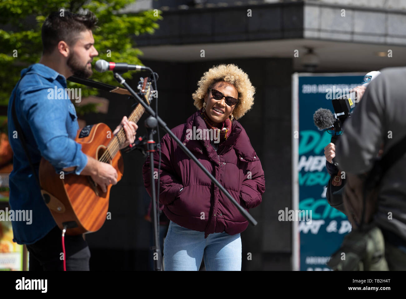 Singer-songwriter Emeli Sande with busking musician Finn Henderson Palmer during filming in her home city of Aberdeen for a new BBC Scotland series 'Emeli Sande's Street Symphony'. Stock Photo