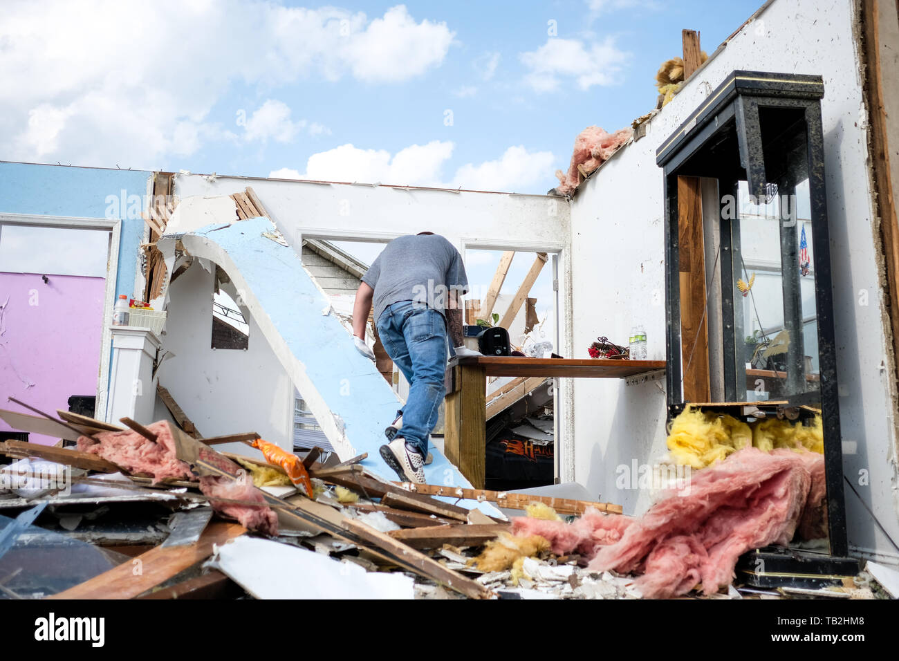 Adam removes personal belongings from his childhood home that was struck by a tornado the night before. At least 1 person is dead and 12 injured from the storms that hit western Ohio. Stock Photo