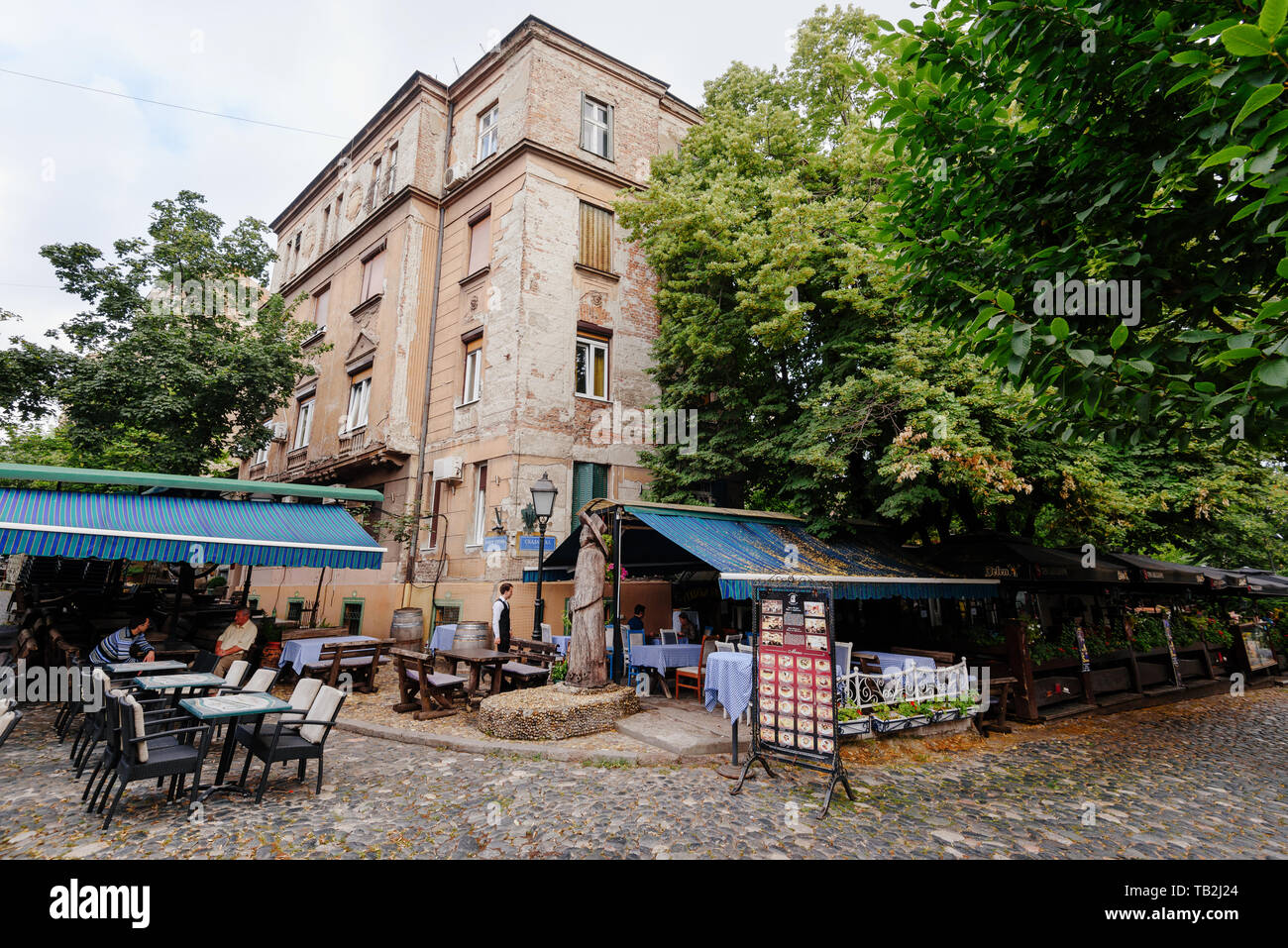 Belgrade, Serbia - June 16, 2018. Historic place Skadarlija with summer cafe terraces, trees, cobbled lanes and alleys in downtown. Bohemian street wi Stock Photo