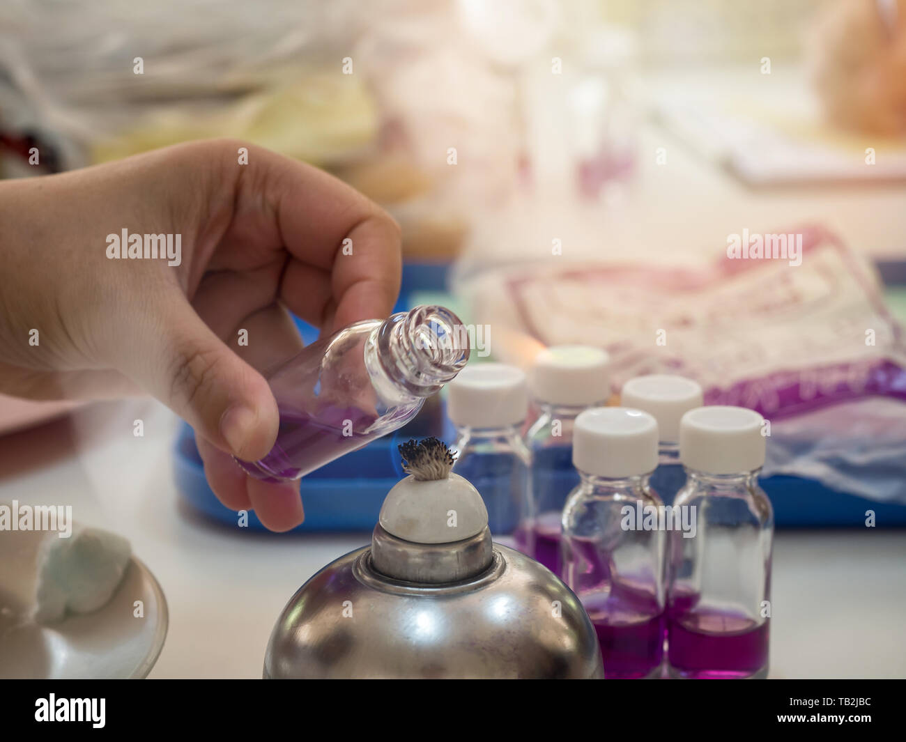 Closeup of bottle being sterilized with an alcohol burner before use