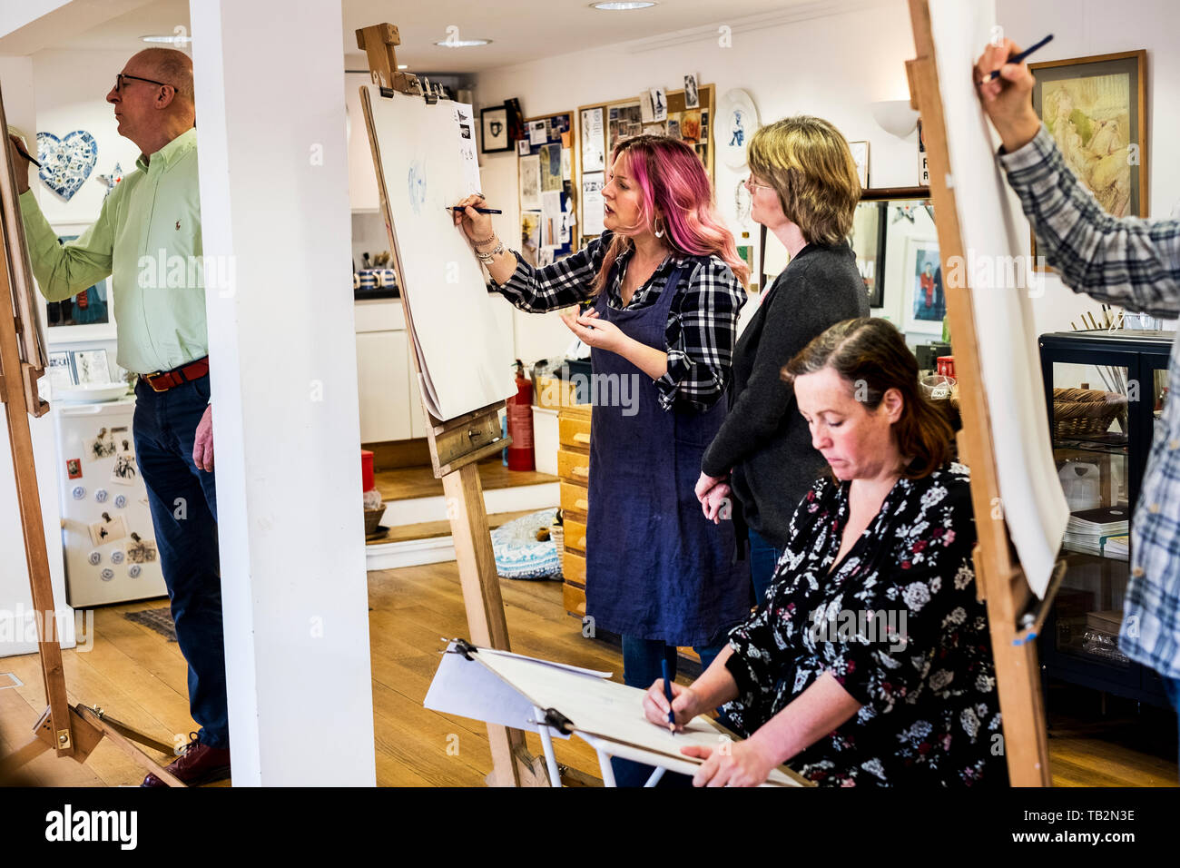 Group of artists standing and sitting at easels, drawing. Stock Photo