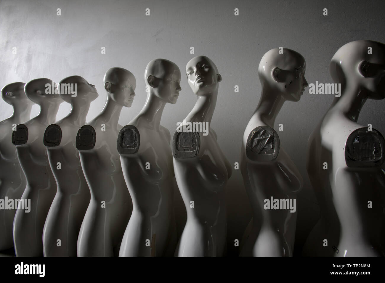 White Woman Torso Figurines Standing in The Line All Looking to Same Direction except of One, Wide angle Closeup Stock Photo