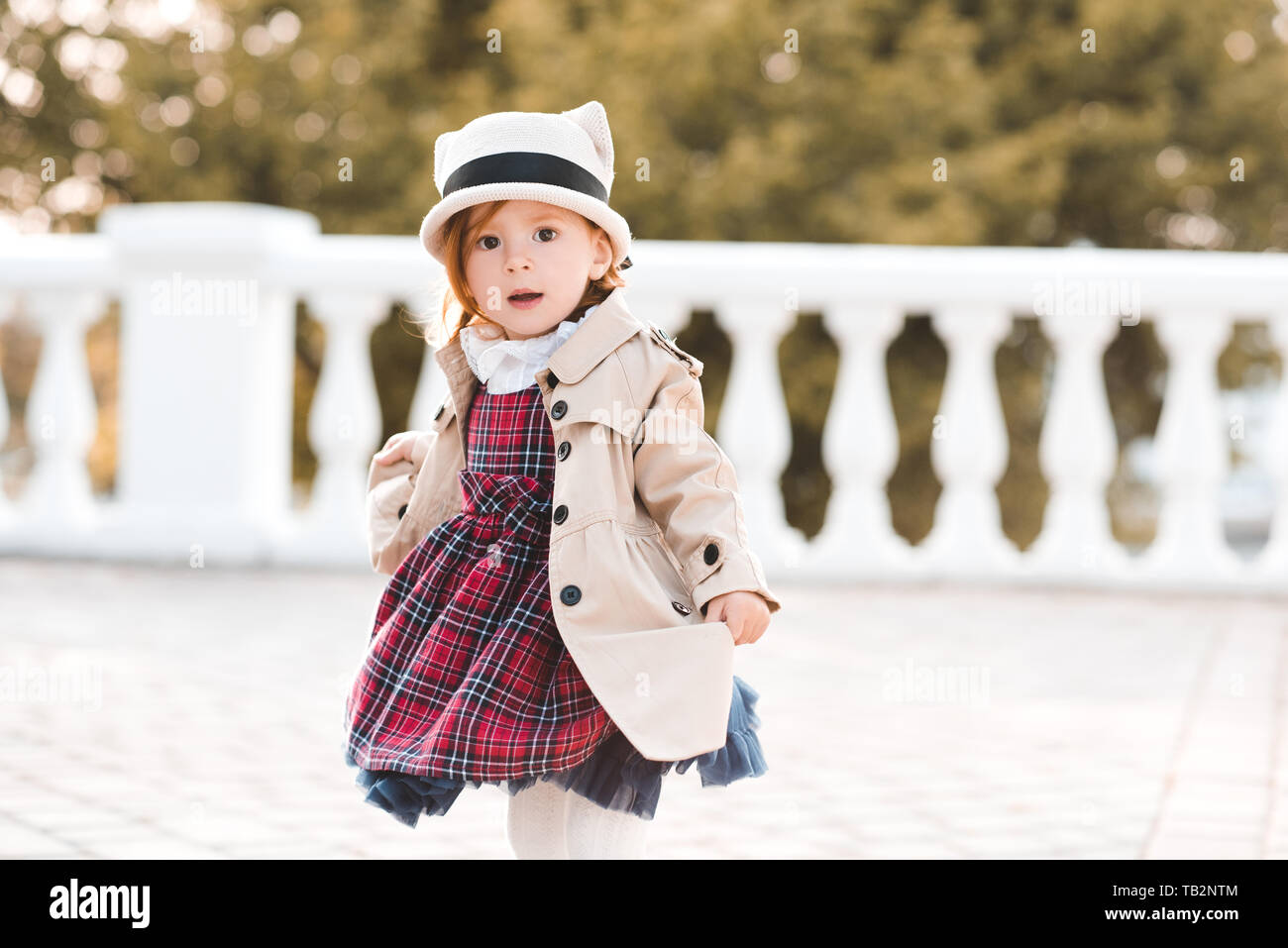 Cute kid girl 1-2 year old wearing stylish clothes over city