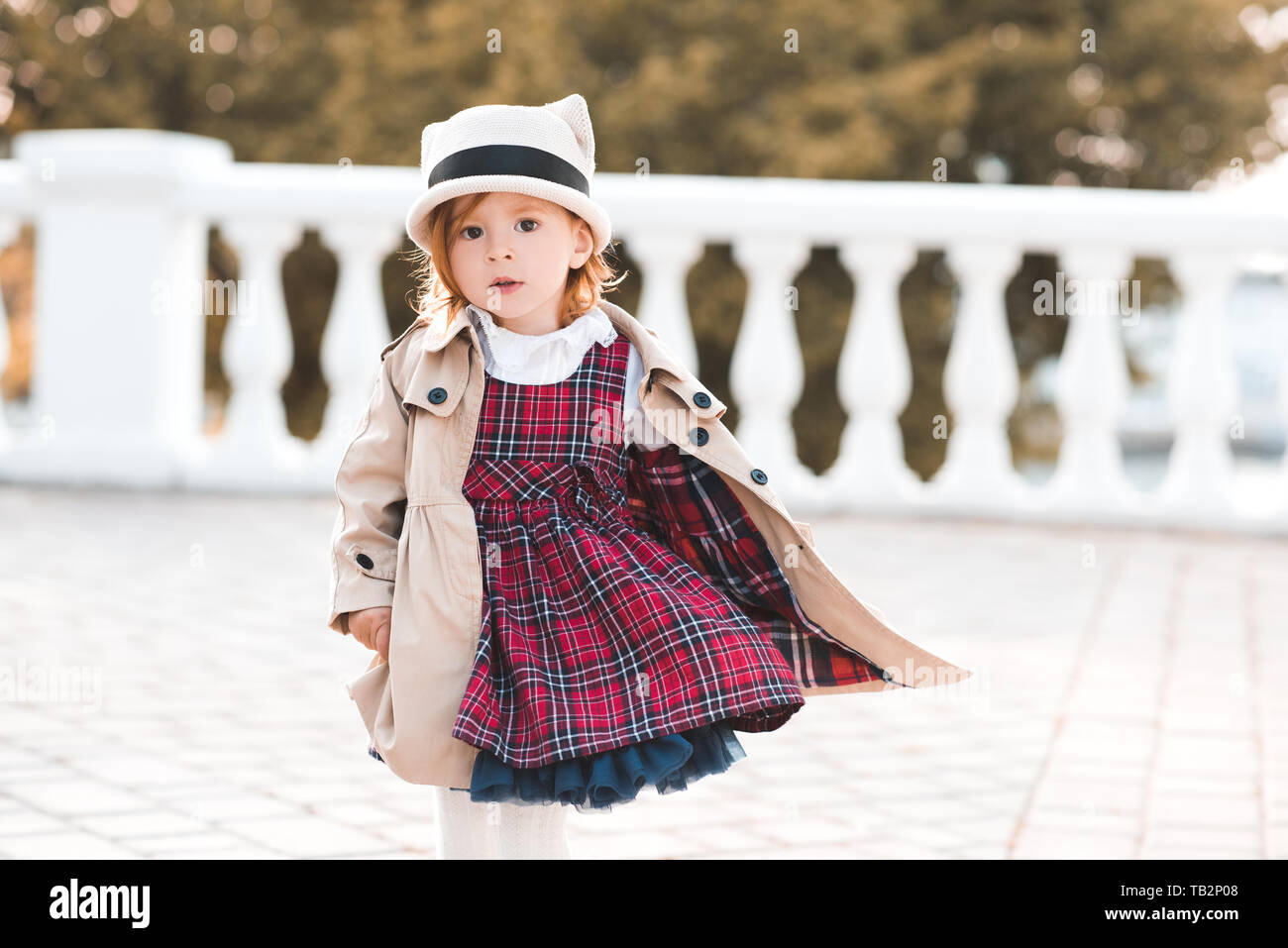 Stylish kid girl 1-2 year old wearing dress and jacket over city