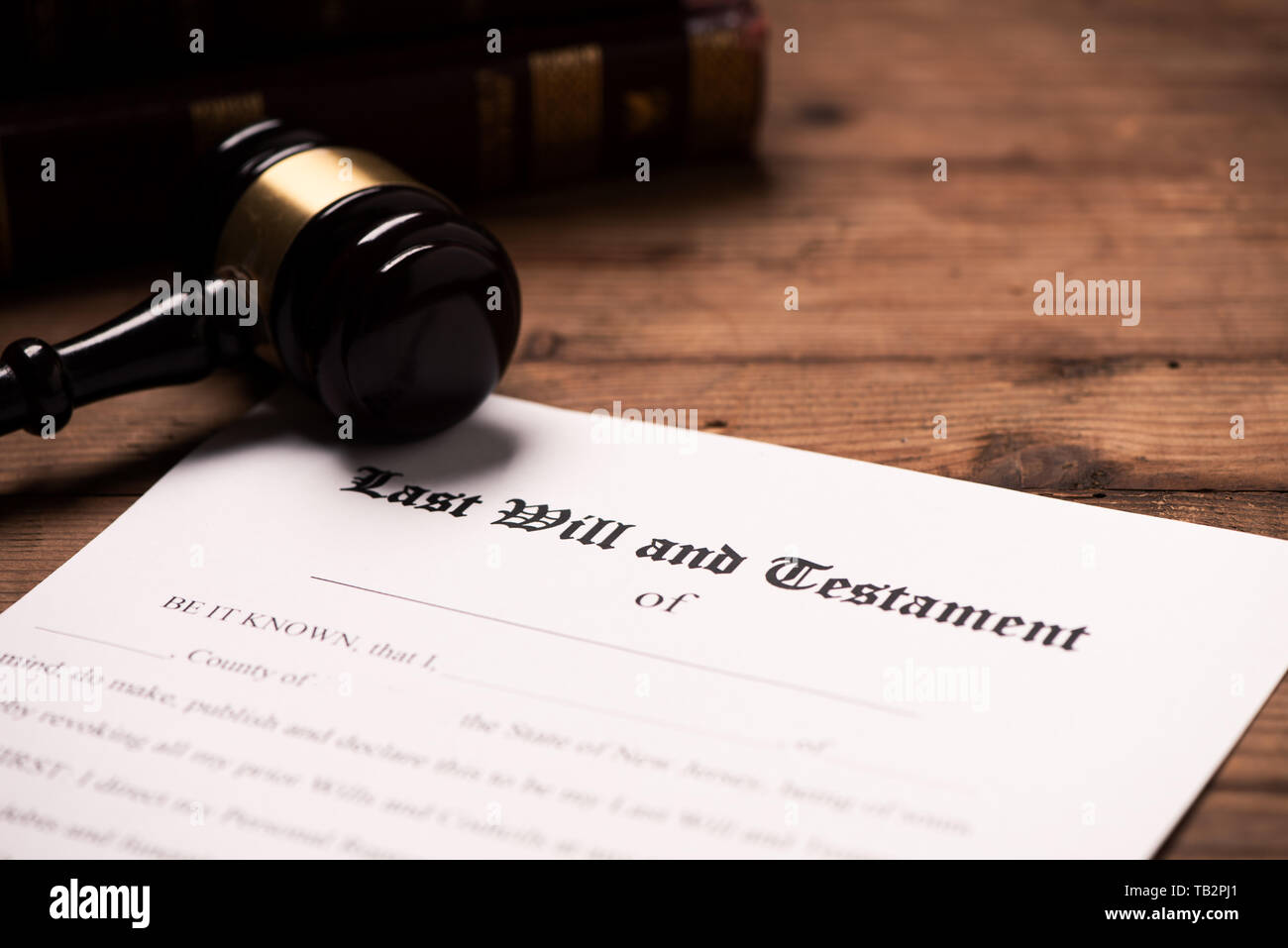 A gavel on top of a Last Will and Testament contract on wooden desk. Close up Stock Photo