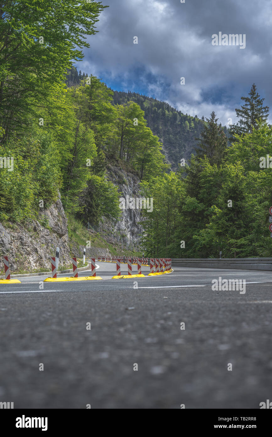 curvy asphalt road in the forest at alps Stock Photo