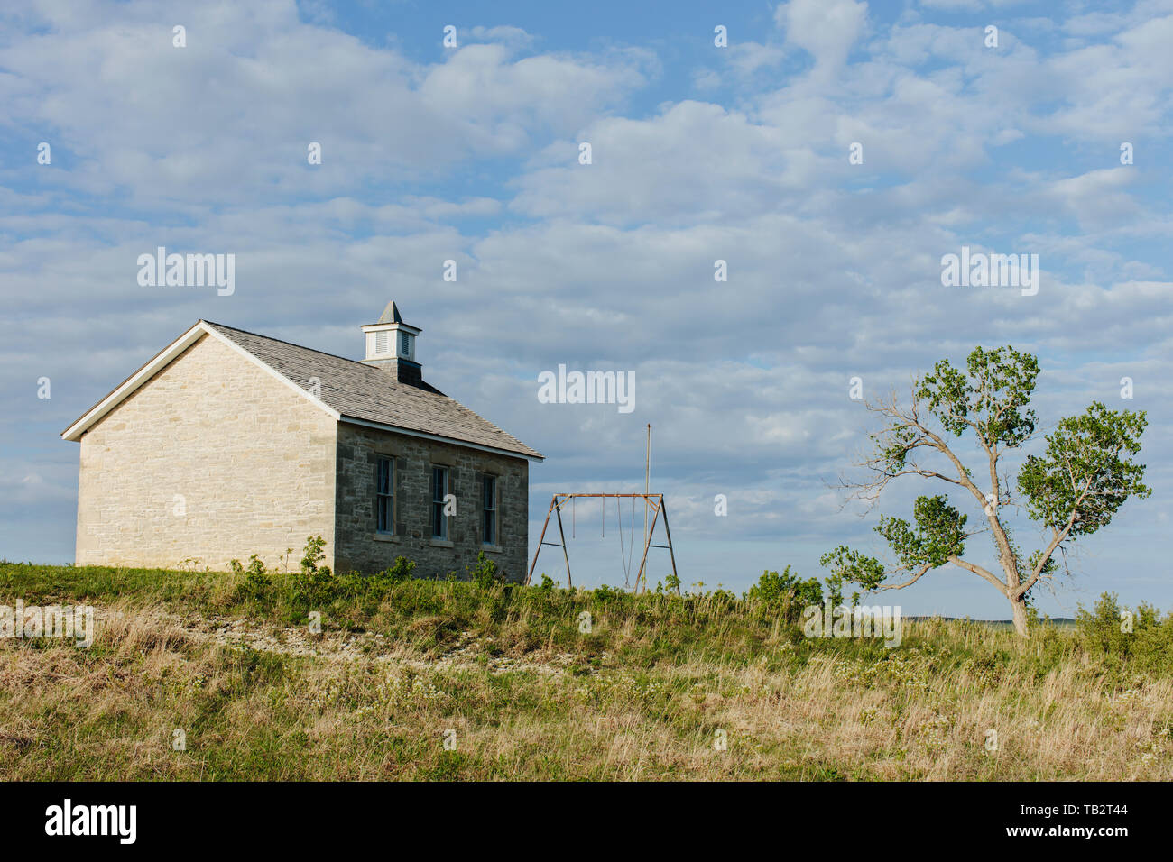 Tallgrass Prairie Preserve, a historic school house building and a cottonwood tree in spring. Stock Photo