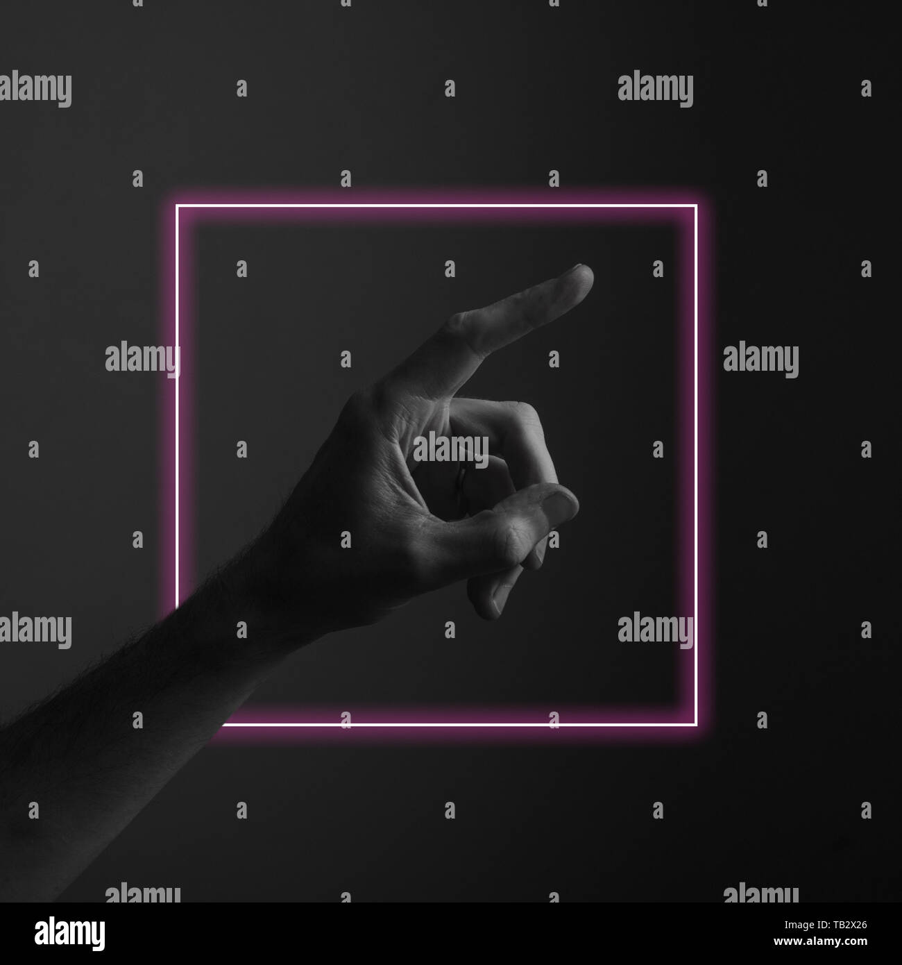 Hand pointing a finger against a dark background with abstract neon ...