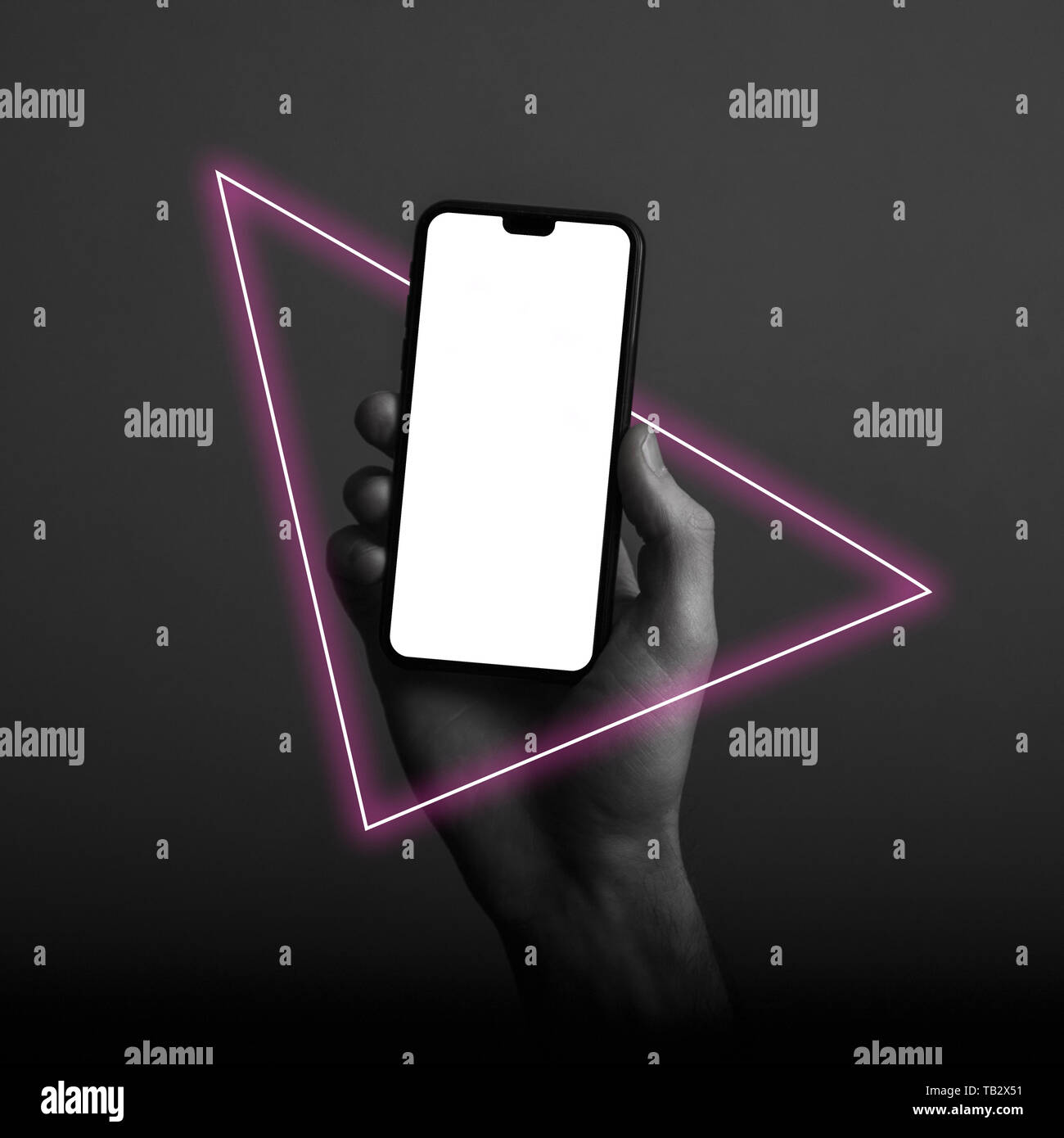 Hand holding modern smartphone with a blank white screen and neon light ...