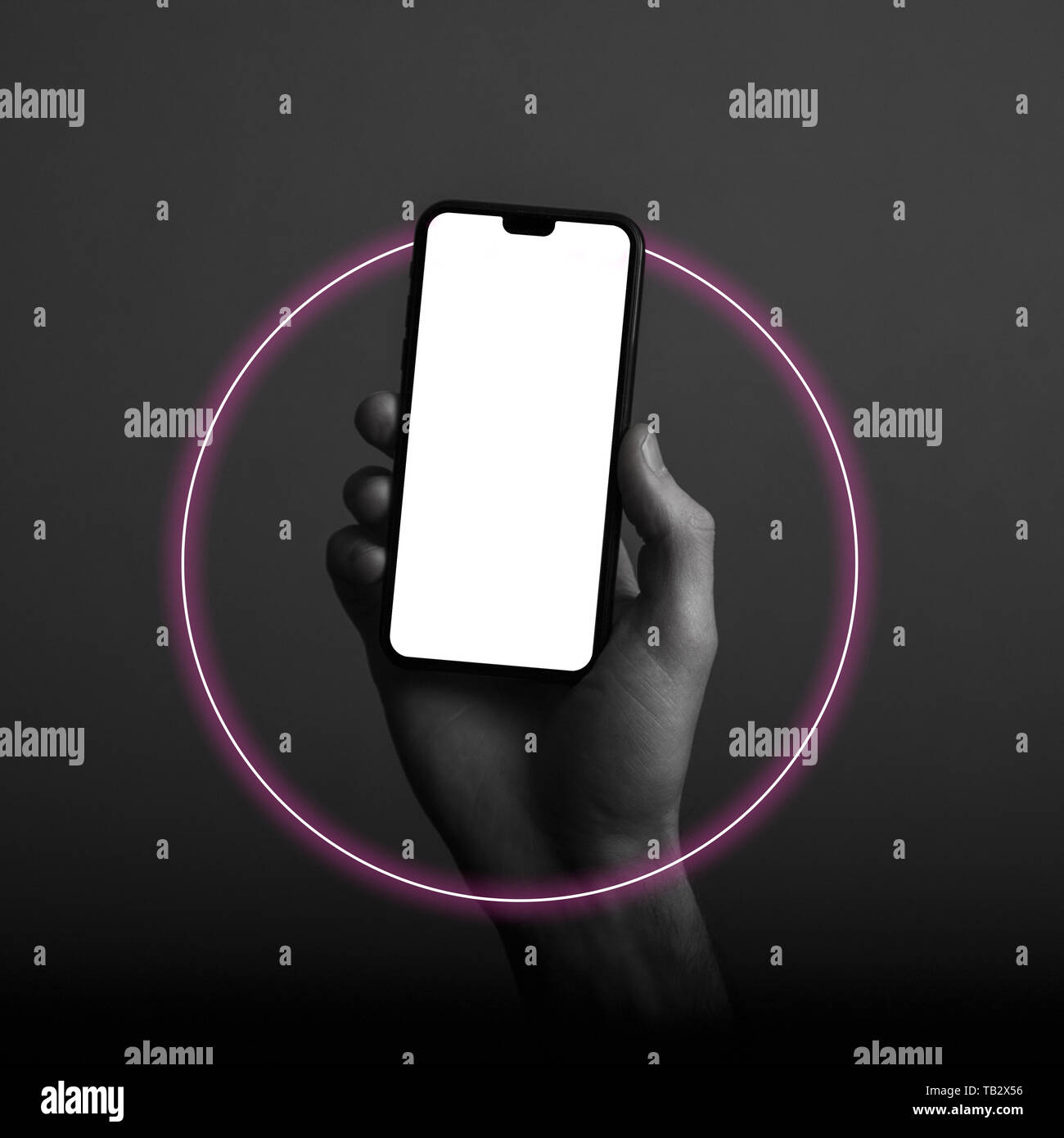 Hand holding modern smartphone with a blank white screen and neon light ...