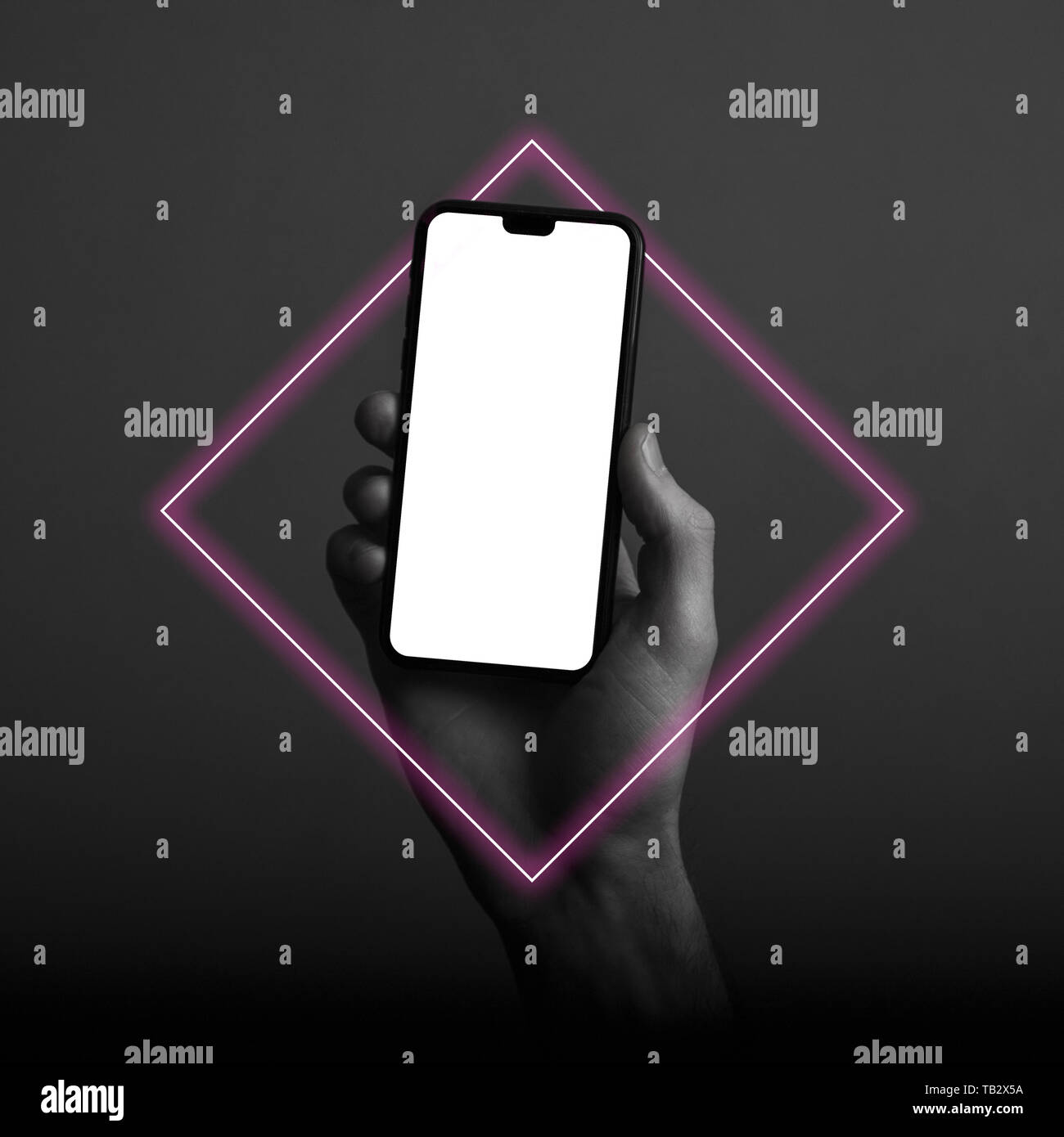 Hand holding modern smartphone with a blank white screen and neon light ...