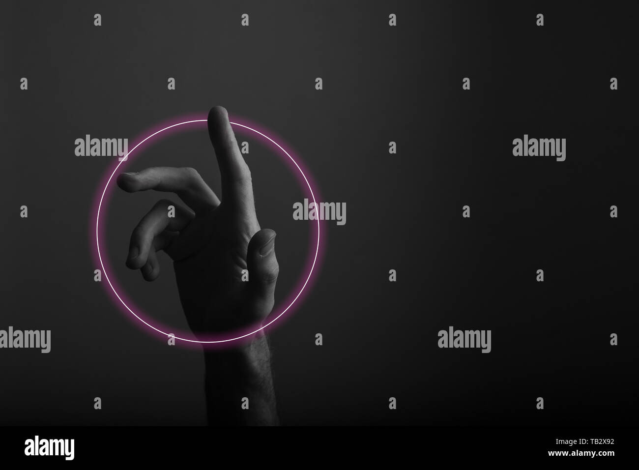 Hand pointing a finger against a dark background with abstract neon ...