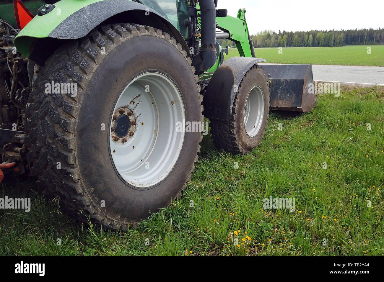 Tractor with front end loader on grass. Low angle side view with copy ...