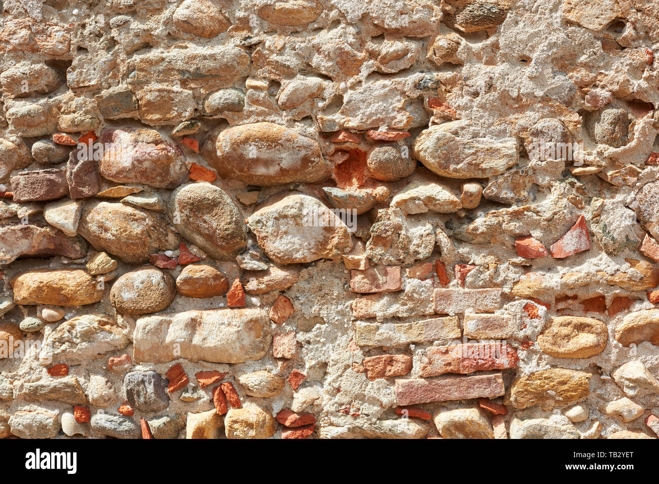 Old bricks and stones wall texture background, sunlight Stock Photo