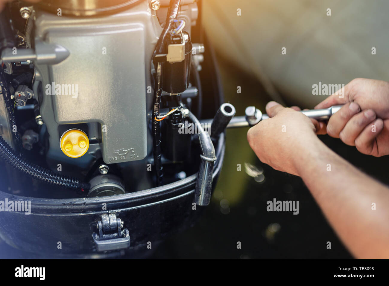 mechanic repairing inflatable motorboat engine at boat garage. Ship