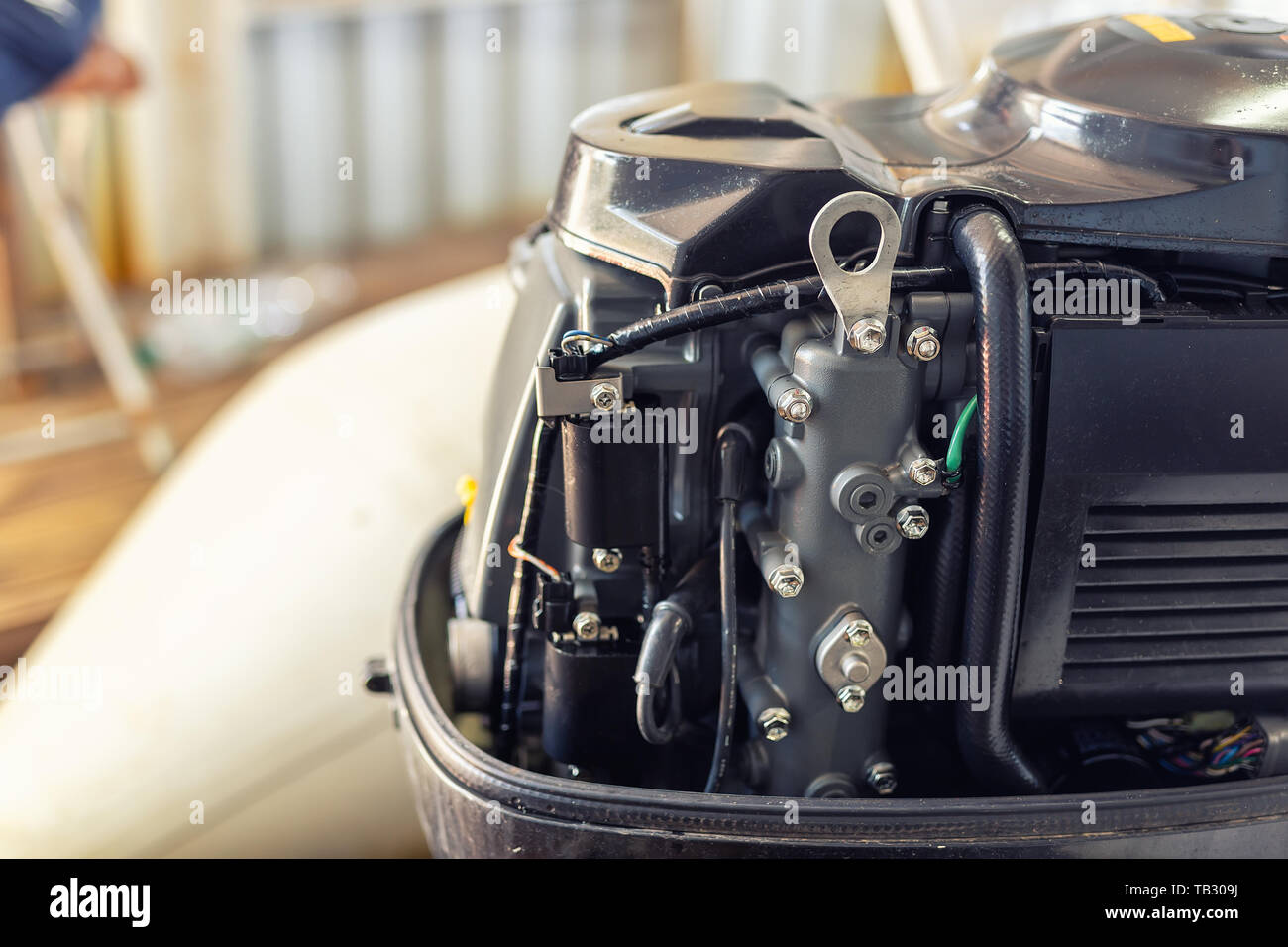 Repairing inflatable motorboat engine at boat garage. Ship engine