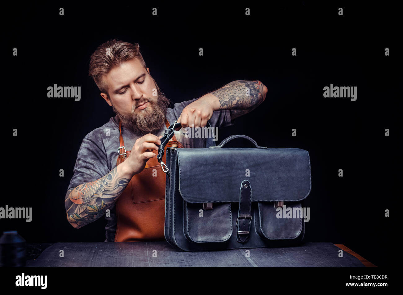 Leather Worker works with leatherwork at his workshop Stock Photo