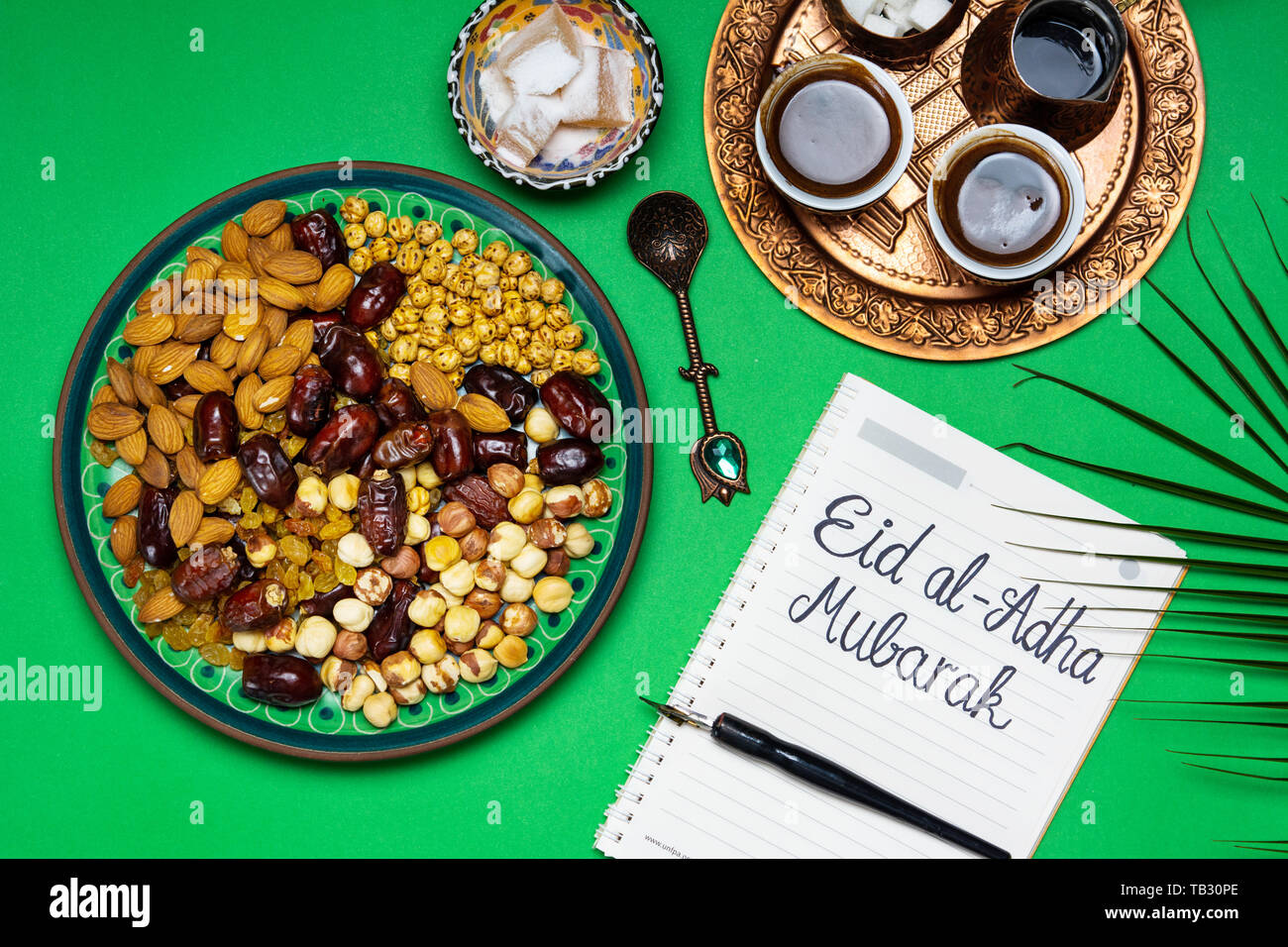 Eid Mubarak note with snacks and coffee on a table Stock Photo
