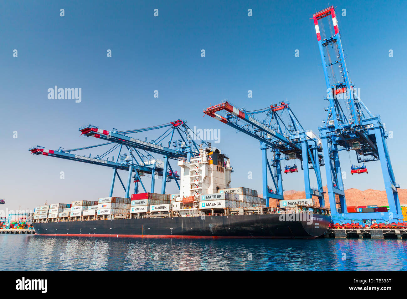 Aqaba, Jordan - May 18, 2018: Gantry cranes load Northern Dependant  container ship. Container terminal. Port of Aqaba city at sunny summer day.  Aqaba Stock Photo - Alamy