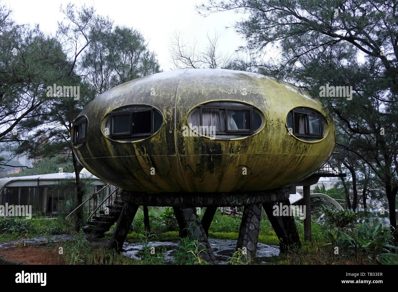Abandoned Sanzhi UFO house in the neighborhood of Wanli region home to the last pod of Futuro “UFO” houses in Sanzhi District, New Taipei, Taiwan. The Sanzhi pod houses or Sanzhi Pod City, were a set of abandoned and never completed pod-shaped buildings a concept from the 1960s envisioned by the Finnish architect Matti Suuronen to solve the problem of mass-producing cheap homes. Stock Photo