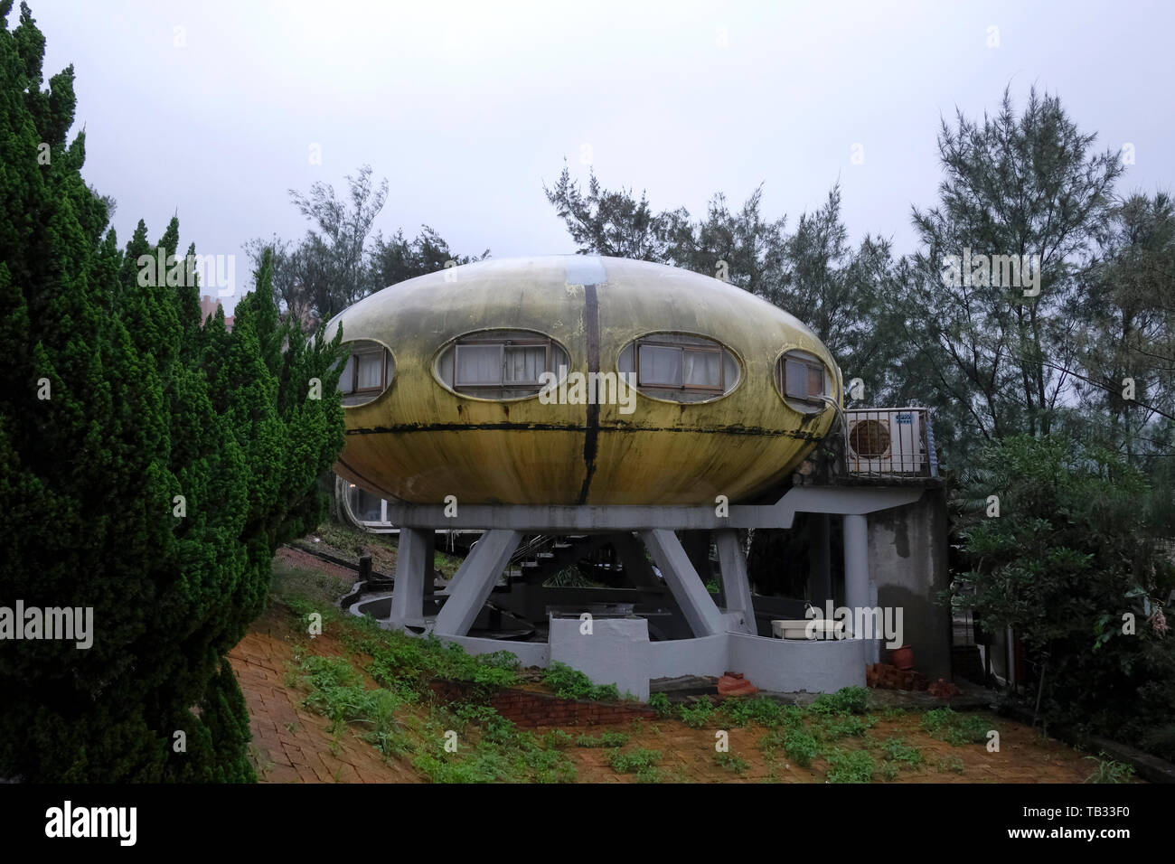 Abandoned Sanzhi UFO house in the neighborhood of Wanli region home to the last pod of Futuro “UFO” houses in Sanzhi District, New Taipei, Taiwan. The Sanzhi pod houses or Sanzhi Pod City, were a set of abandoned and never completed pod-shaped buildings a concept from the 1960s envisioned by the Finnish architect Matti Suuronen to solve the problem of mass-producing cheap homes. Stock Photo