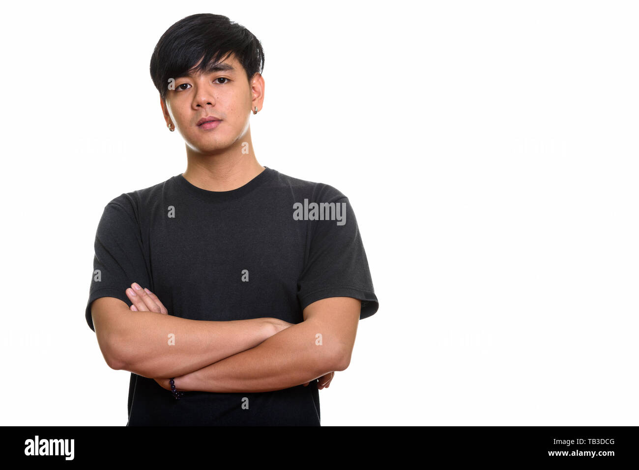 Studio shot of cool handsome Asian man with arms crossed Stock Photo