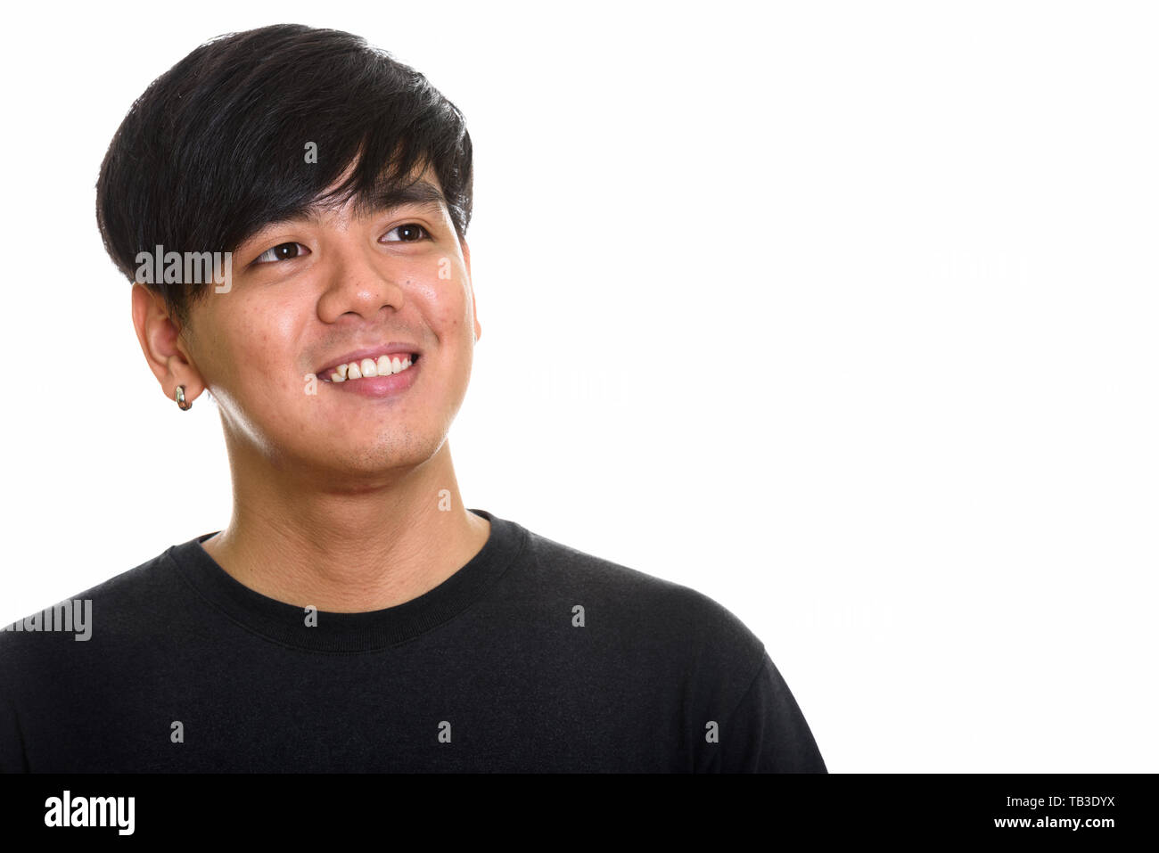 Studio shot of cool happy Asian man smiling and thinking Stock Photo