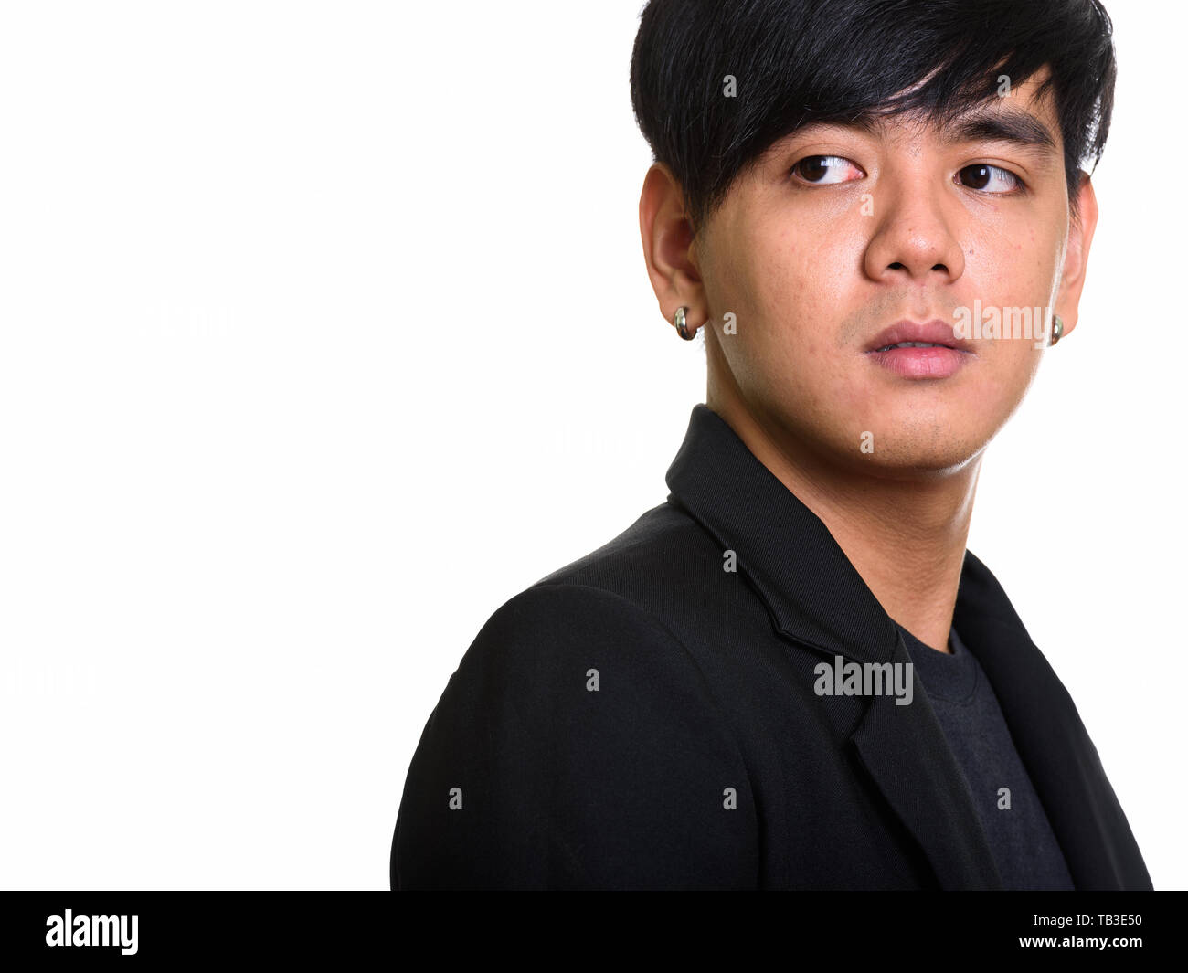 Studio shot of cool handsome Asian man looking back Stock Photo