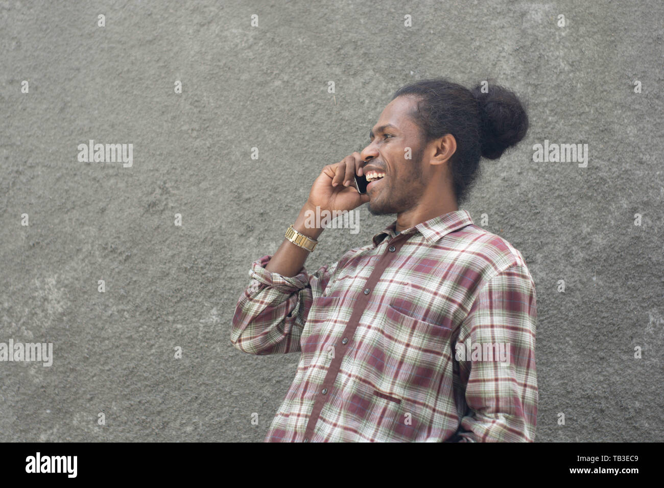 young bearded black man in casual dress using smartphone Stock Photo