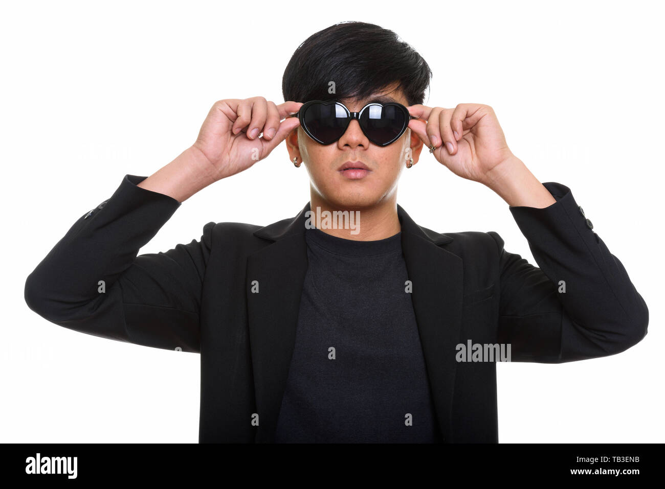 Studio shot of cool handsome Asian man wearing and holding heart Stock Photo