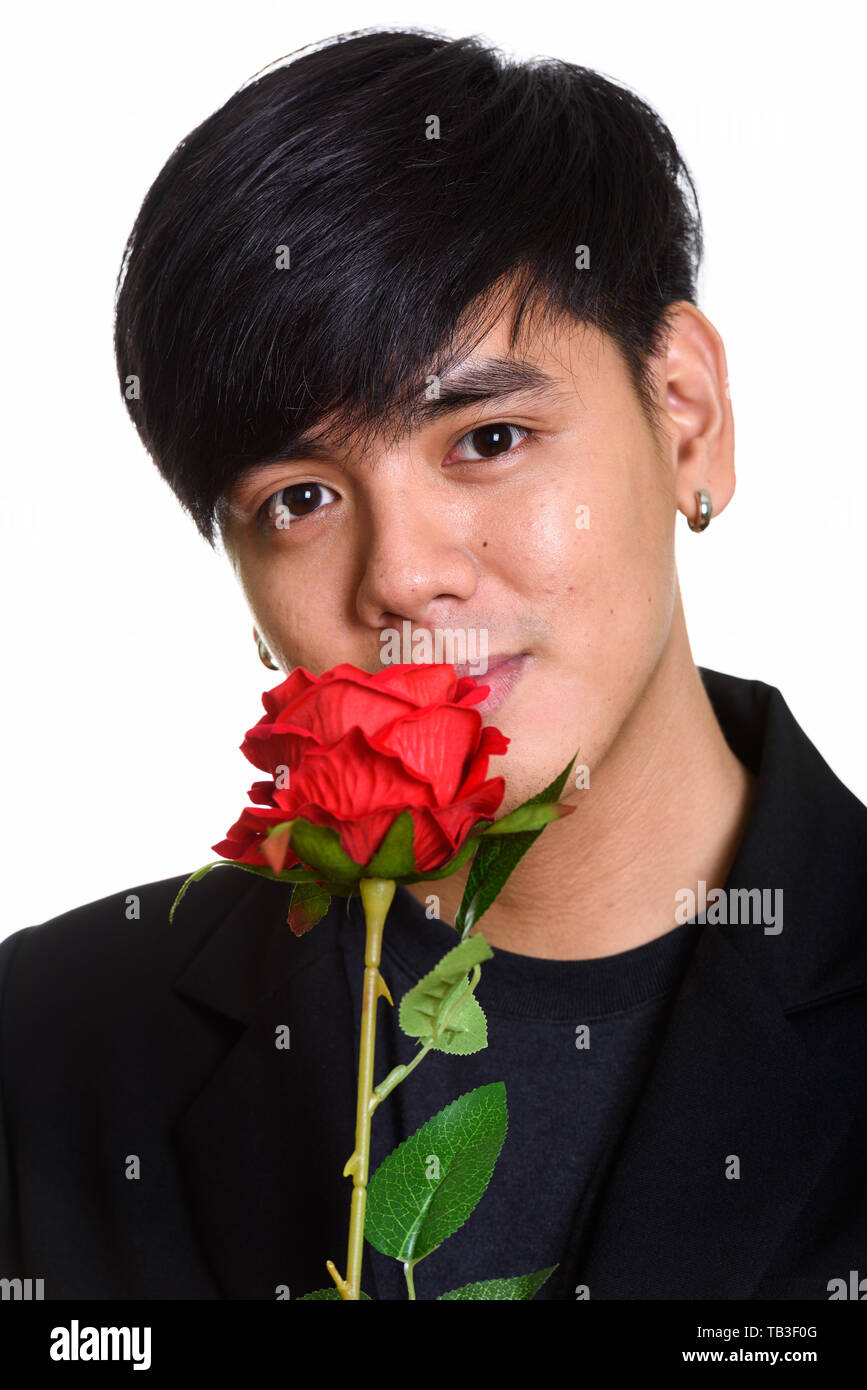 Face of cool handsome Asian man smelling red roses Stock Photo