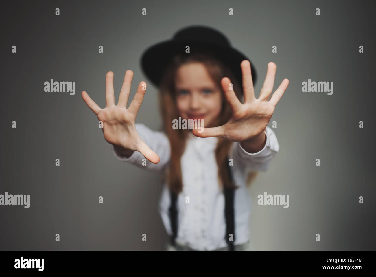cute little girl with black hat at home Stock Photo
