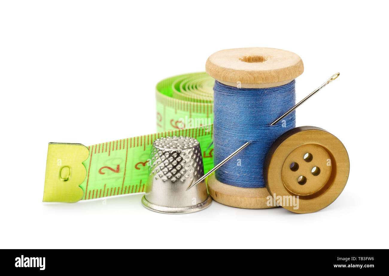 Spool of blue thread, needle, button, measuring tape and thimble isolated on white Stock Photo