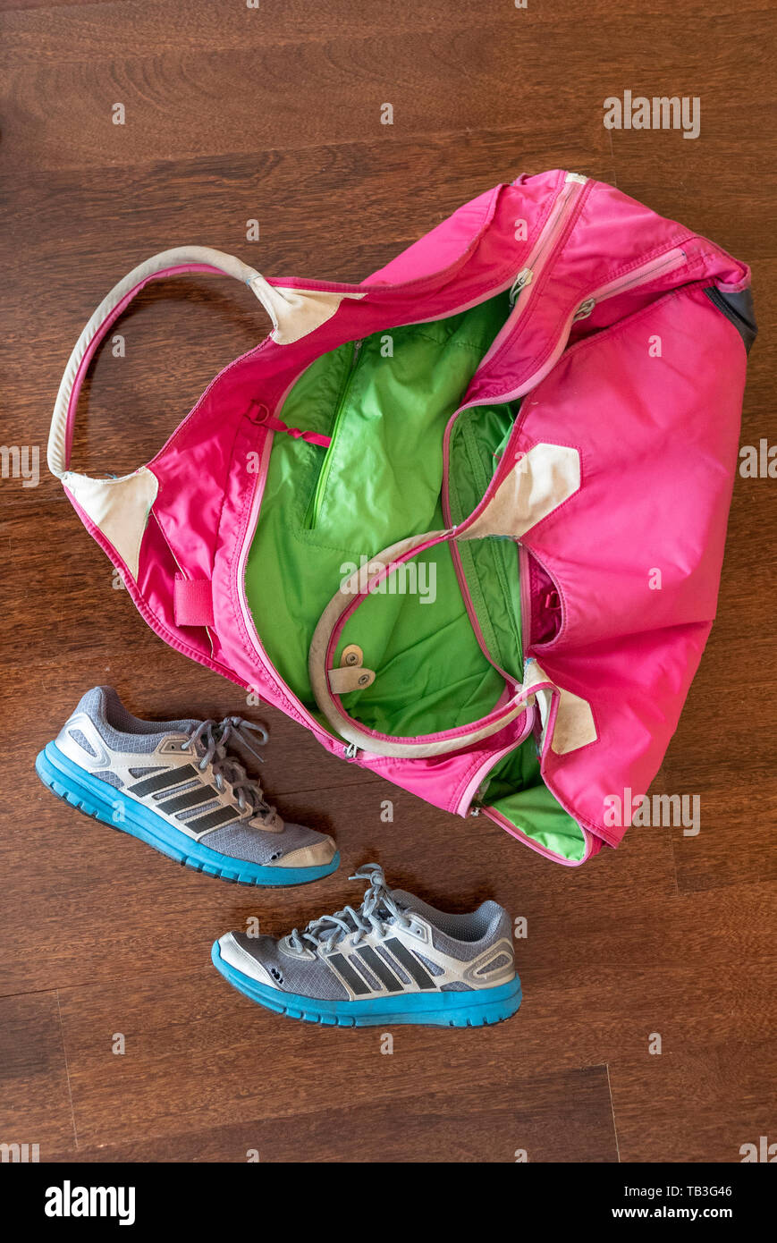 Worn pink gym bag and blue Adidas sneakers Stock Photo - Alamy