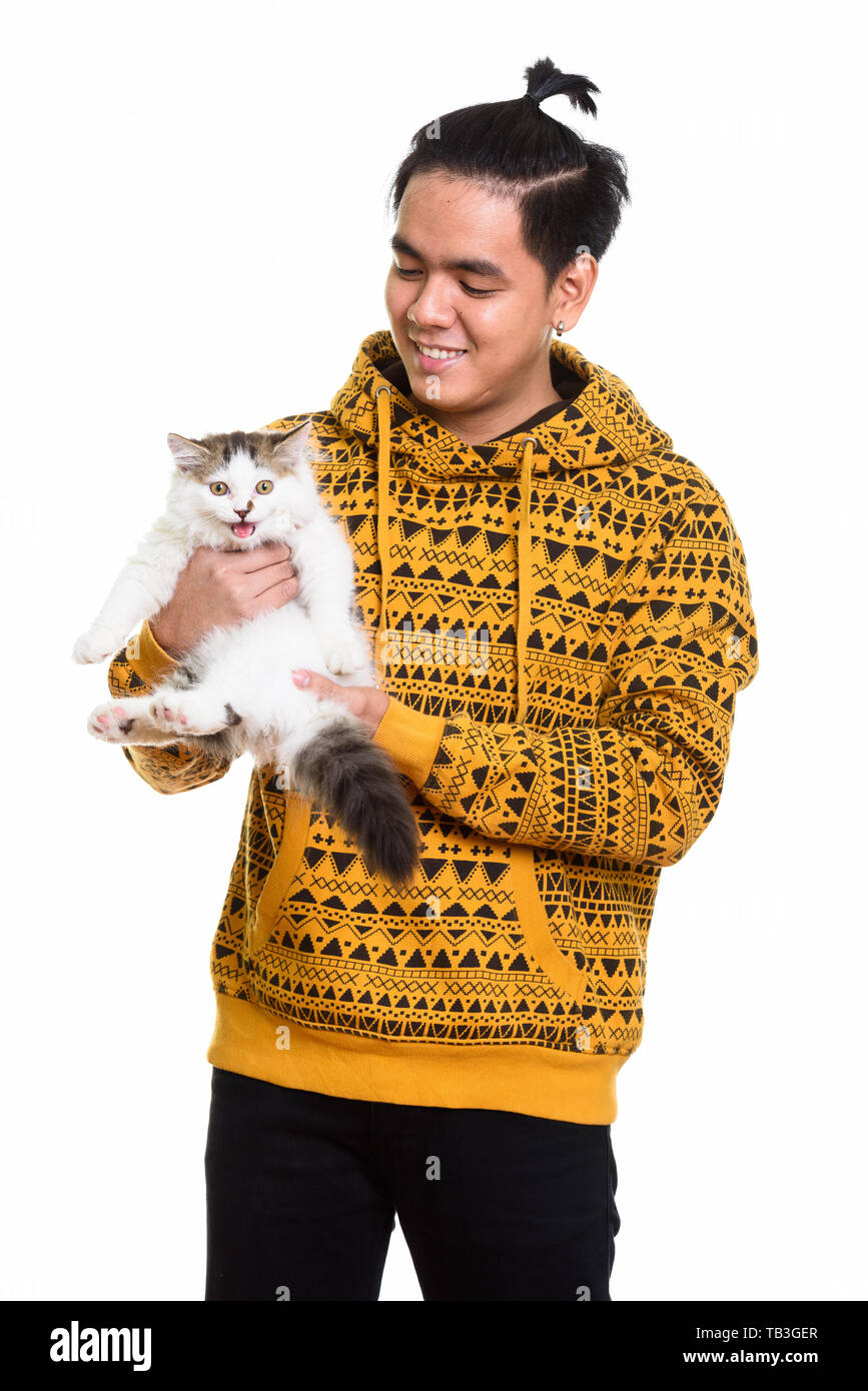 Studio shot of happy Asian man smiling while holding cute cat Stock Photo