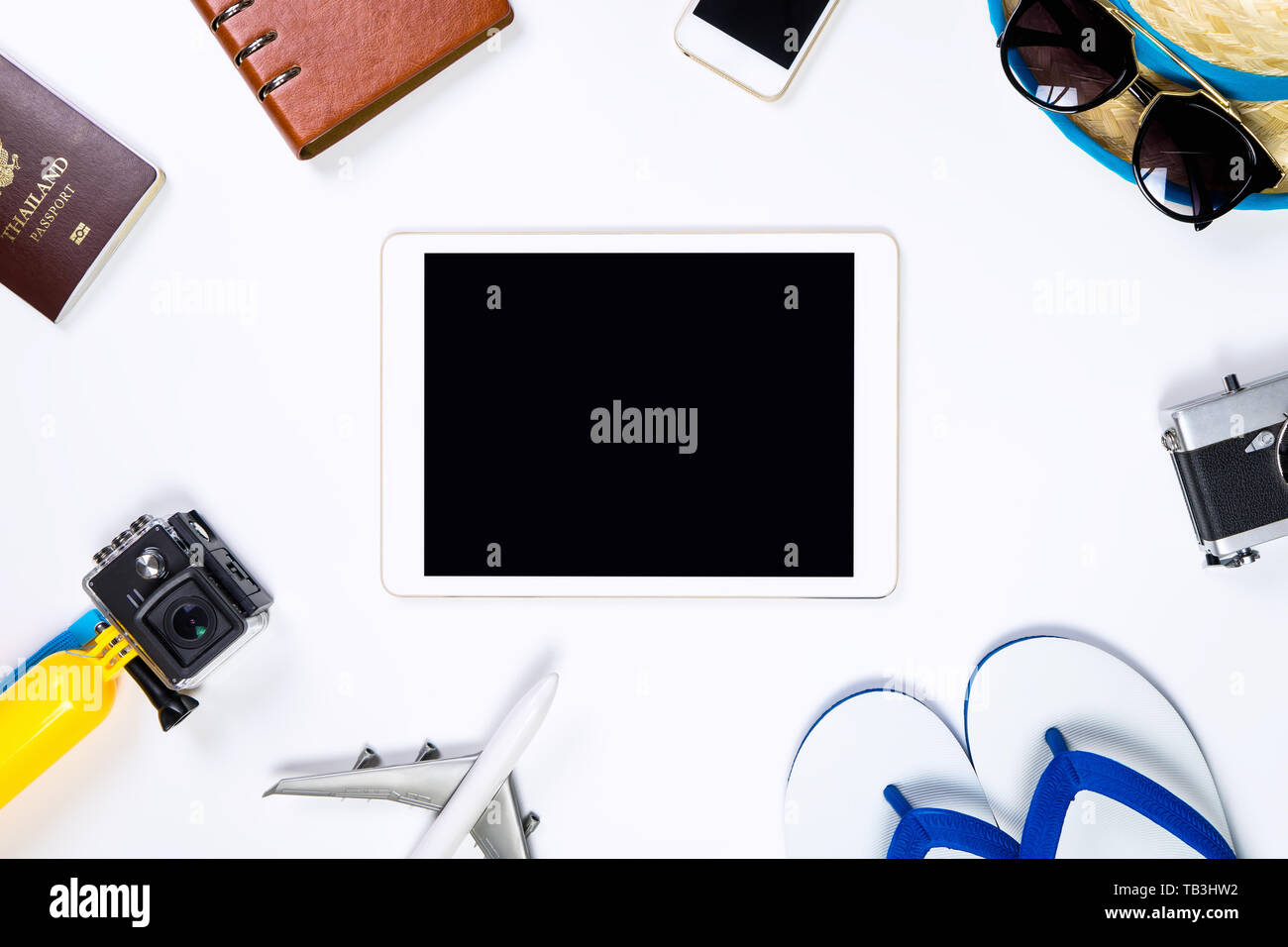 Blank tablet screen surrounding by travel objects Stock Photo