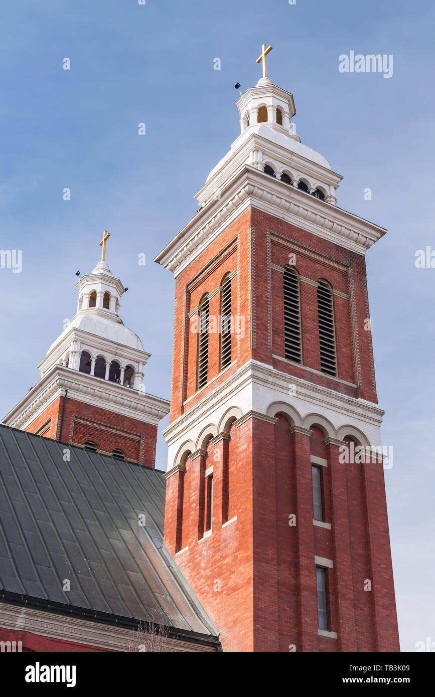 The twin bell towers of Our Lady of Lourdes in Spokane stand out against the blue sky of early spring Stock Photo