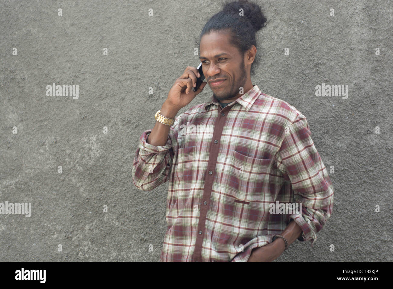 young bearded black man in casual dress using smartphone Stock Photo