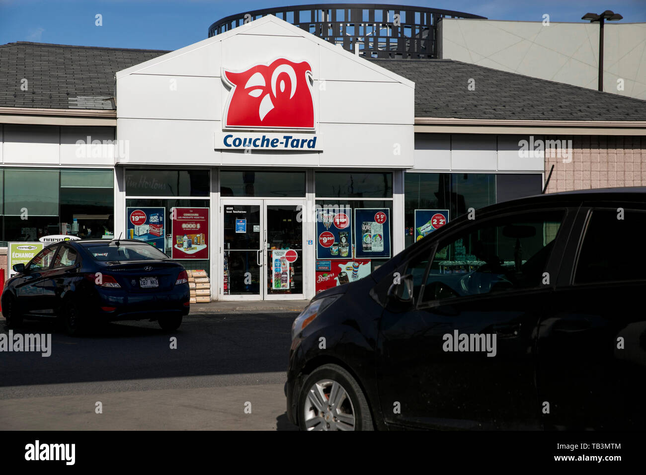 A logo sign outside of a Couche-Tard convenience store location in Brossard, Quebec, Canada, on April 23, 2019. Stock Photo