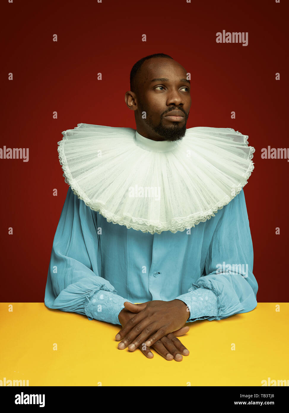 Grandee Young man as a medieval grandee or nobleman on red studio background ...
