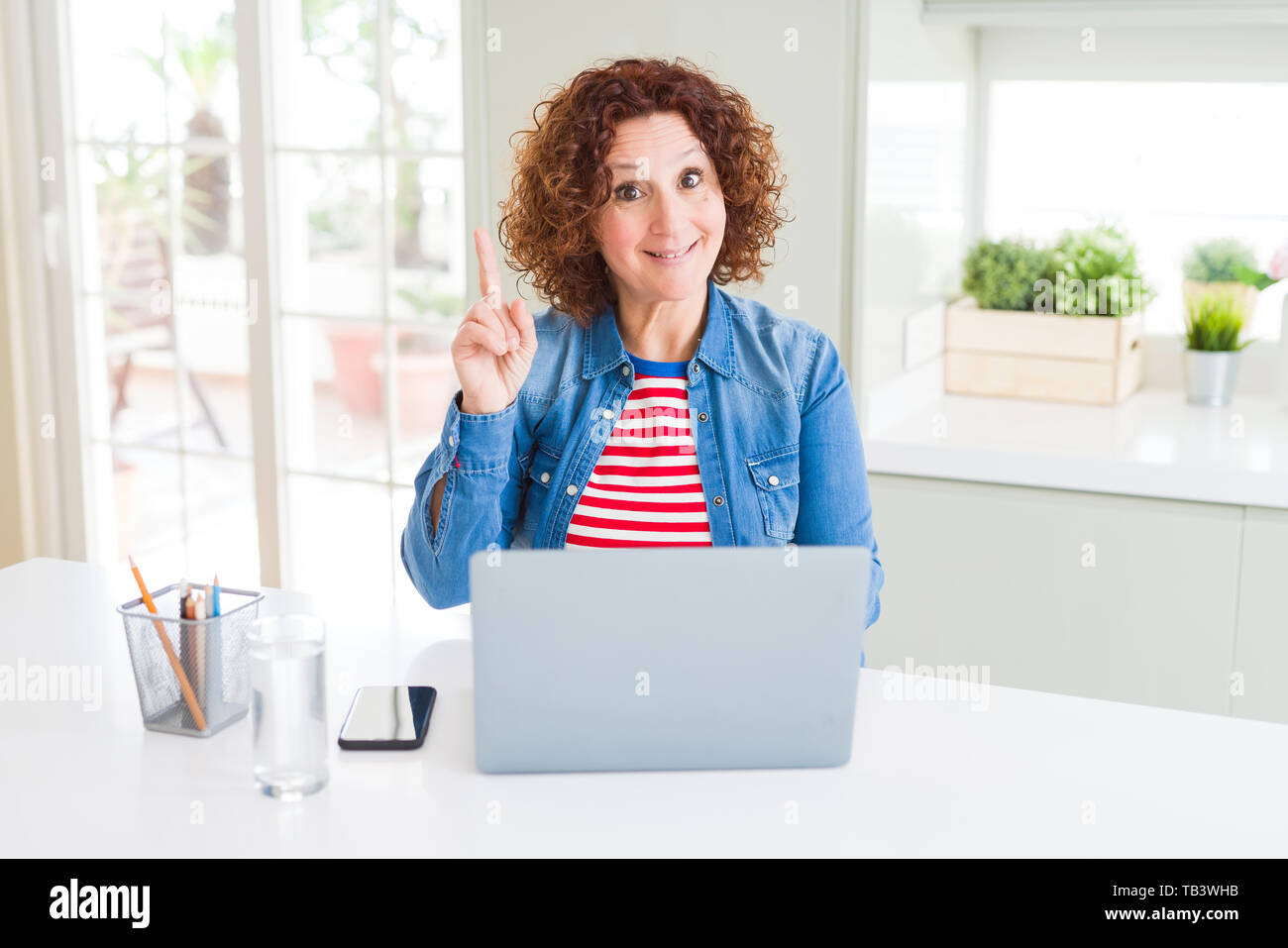 Senior woman working using computer laptop surprised with an idea or ...