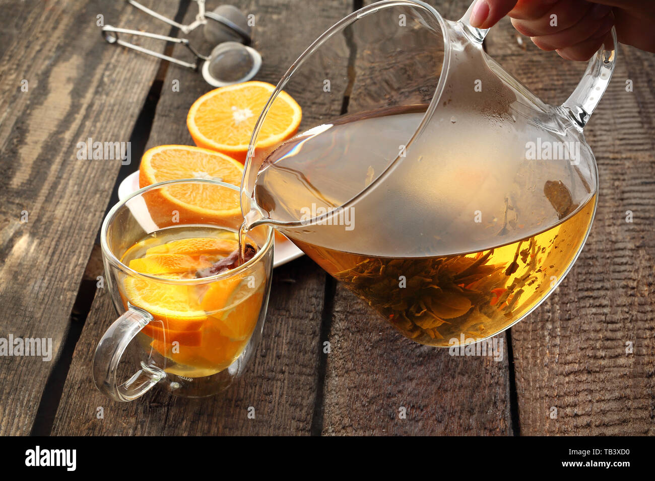 Blossoming green tea with orange, a glass of hot aromatic drink. Stock Photo